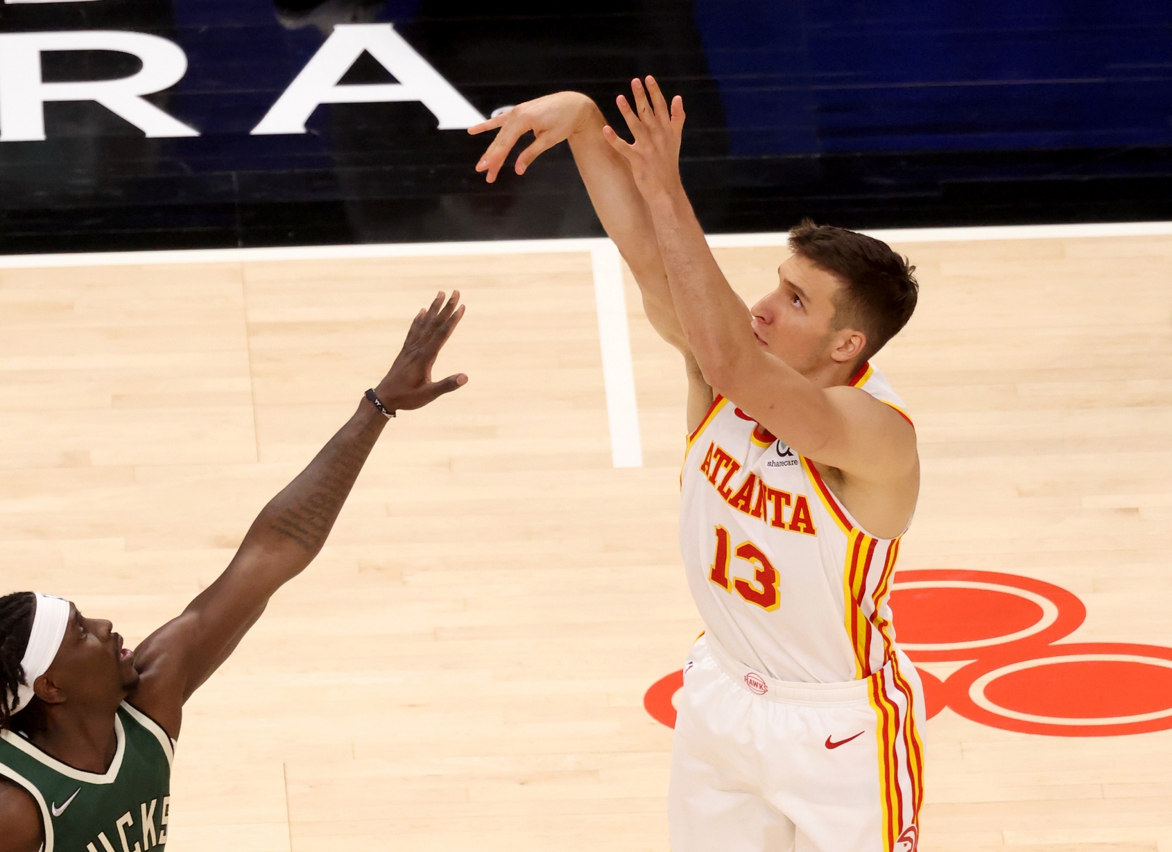 Apr 25, 2021; Atlanta, Georgia, USA; Atlanta Hawks guard Bogdan Bogdanovic (13) attempts a shot against Milwaukee Bucks guard Jrue Holiday (21) during the fourth quarter at State Farm Arena. Mandatory Credit: Jason Getz-USA TODAY Sports