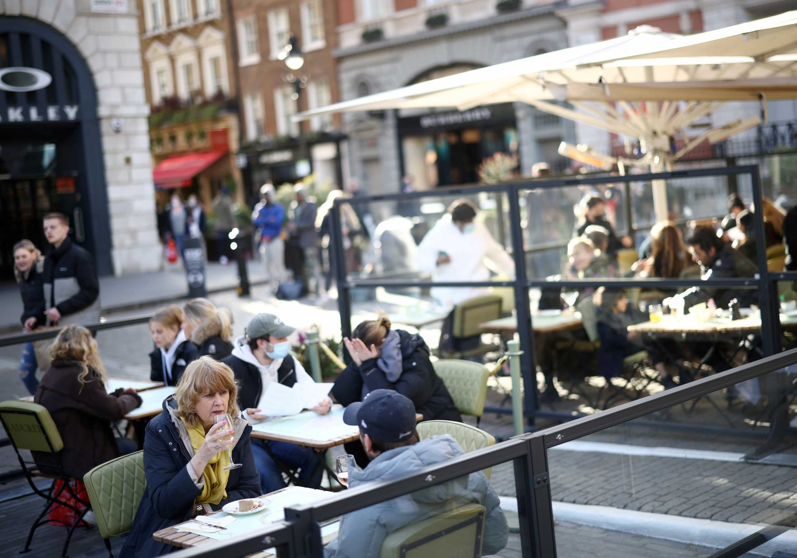 FILE PHOTO: People sit at an outside restaurant area, as the coronavirus disease (COVID-19) restrictions ease, at Covent Garden in London, Britain April 12, 2021. REUTERS