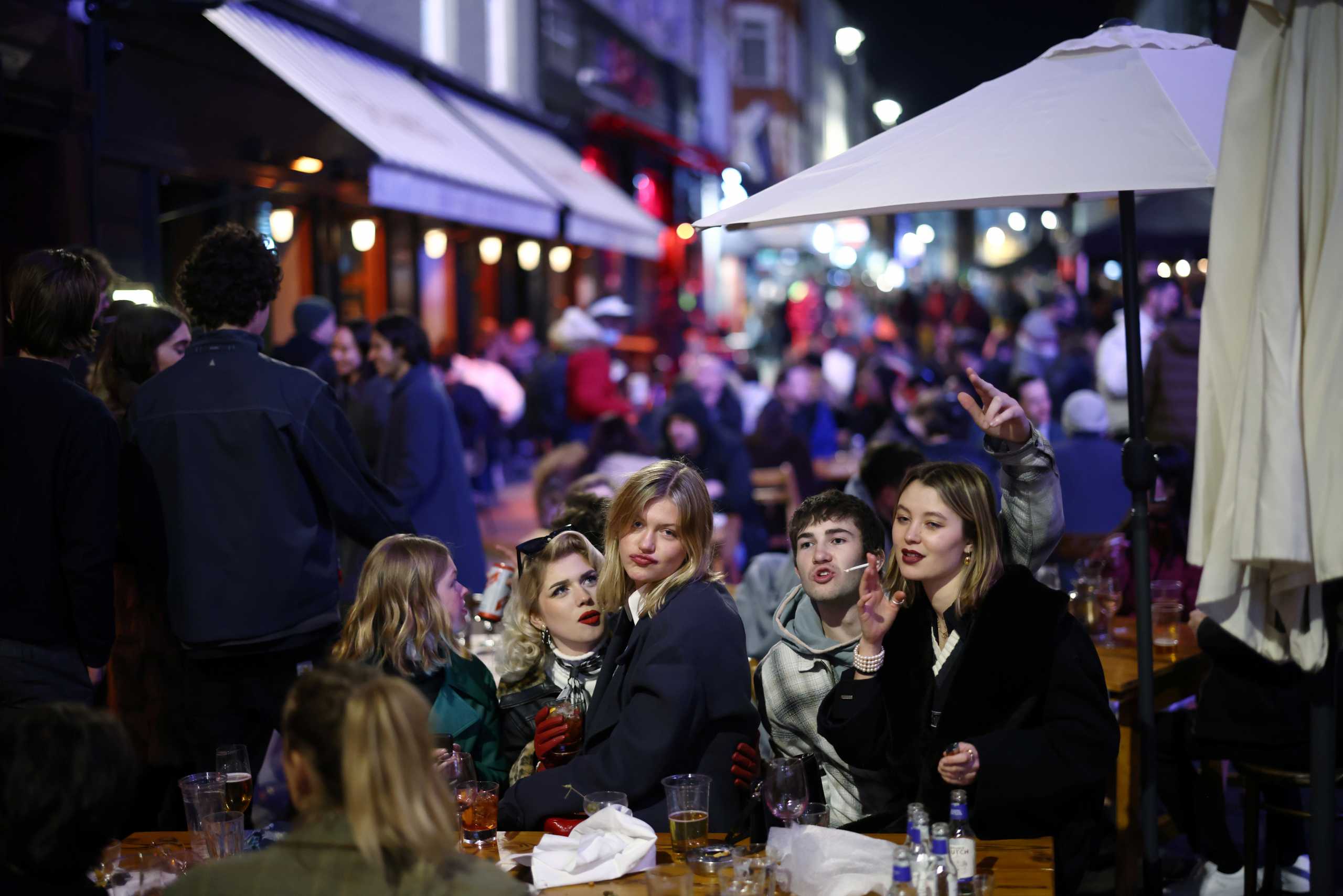 People enjoy the evening at an outside restaurant area in Soho, as the coronavirus disease (COVID-19) restrictions ease, in London, Britain April 12, 2021. REUTERS