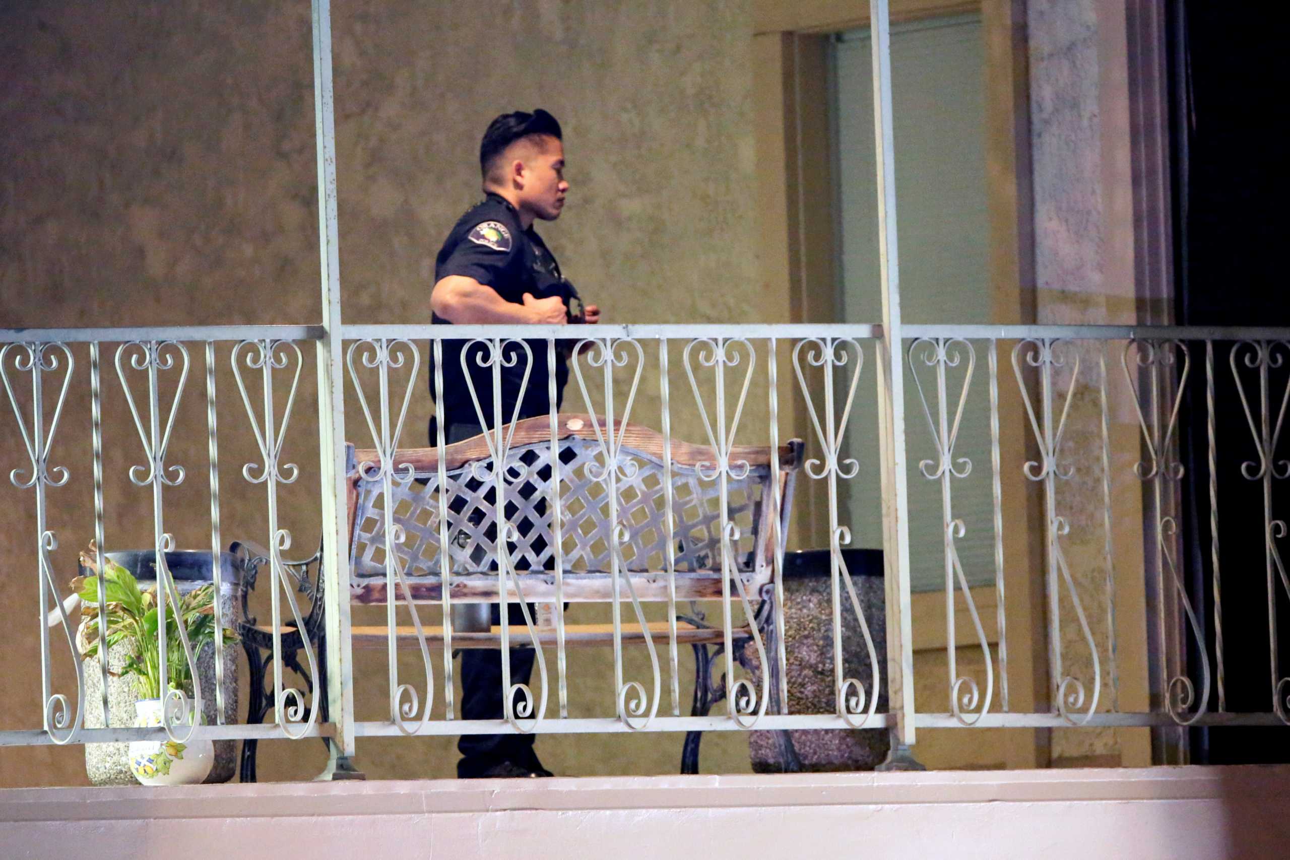 A police officer walks on a balcony in a building after a shooting in Orange, California, U.S. March 31, 2021.   REUTERS