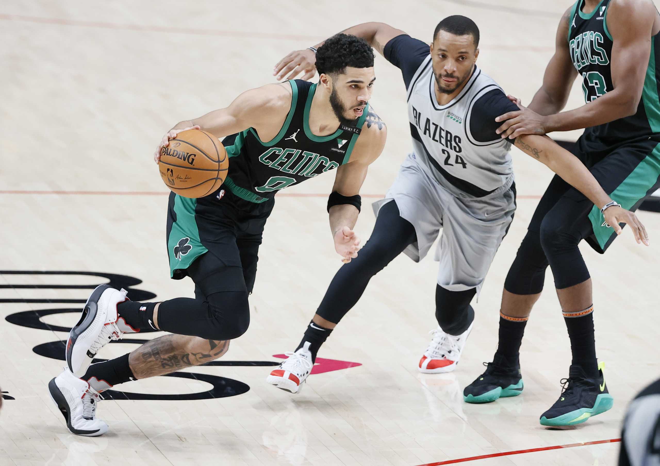 Apr 13, 2021; Portland, Oregon, USA; Boston Celtics small forward Jayson Tatum (0) dribbles the ball against Portland Trail Blazers small forward Norman Powell (24) during the second half at Moda Center. Mandatory Credit: Soobum Im-USA TODAY Sports