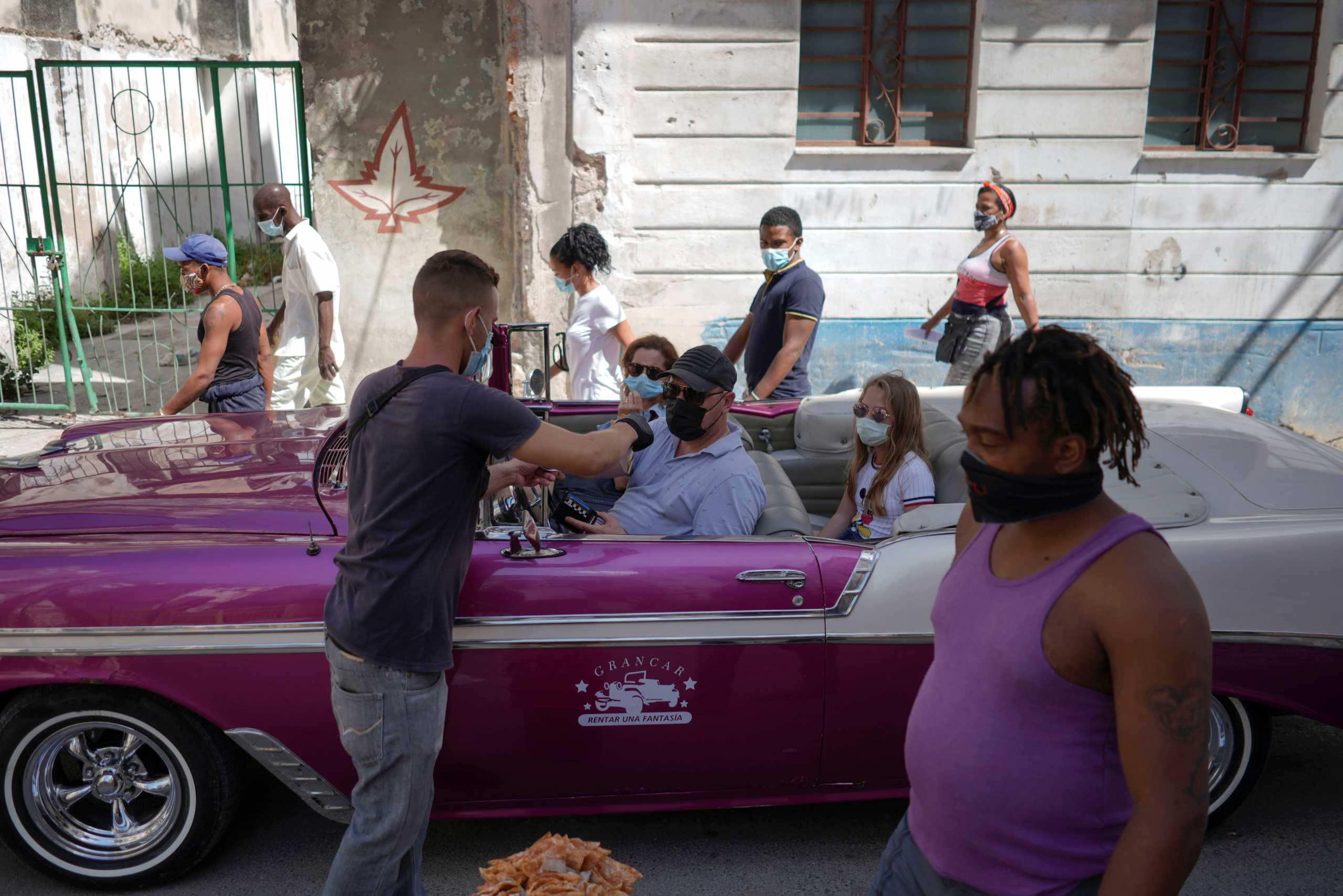 Alejandro Aleman, together with his family, rides his car normally used as taxi for tourists in downtown Havana amid the outbreak of the coronavirus disease (COVID-19), Cuba, March 30, 2021. Picture taken on March 30, 2021. REUTERS