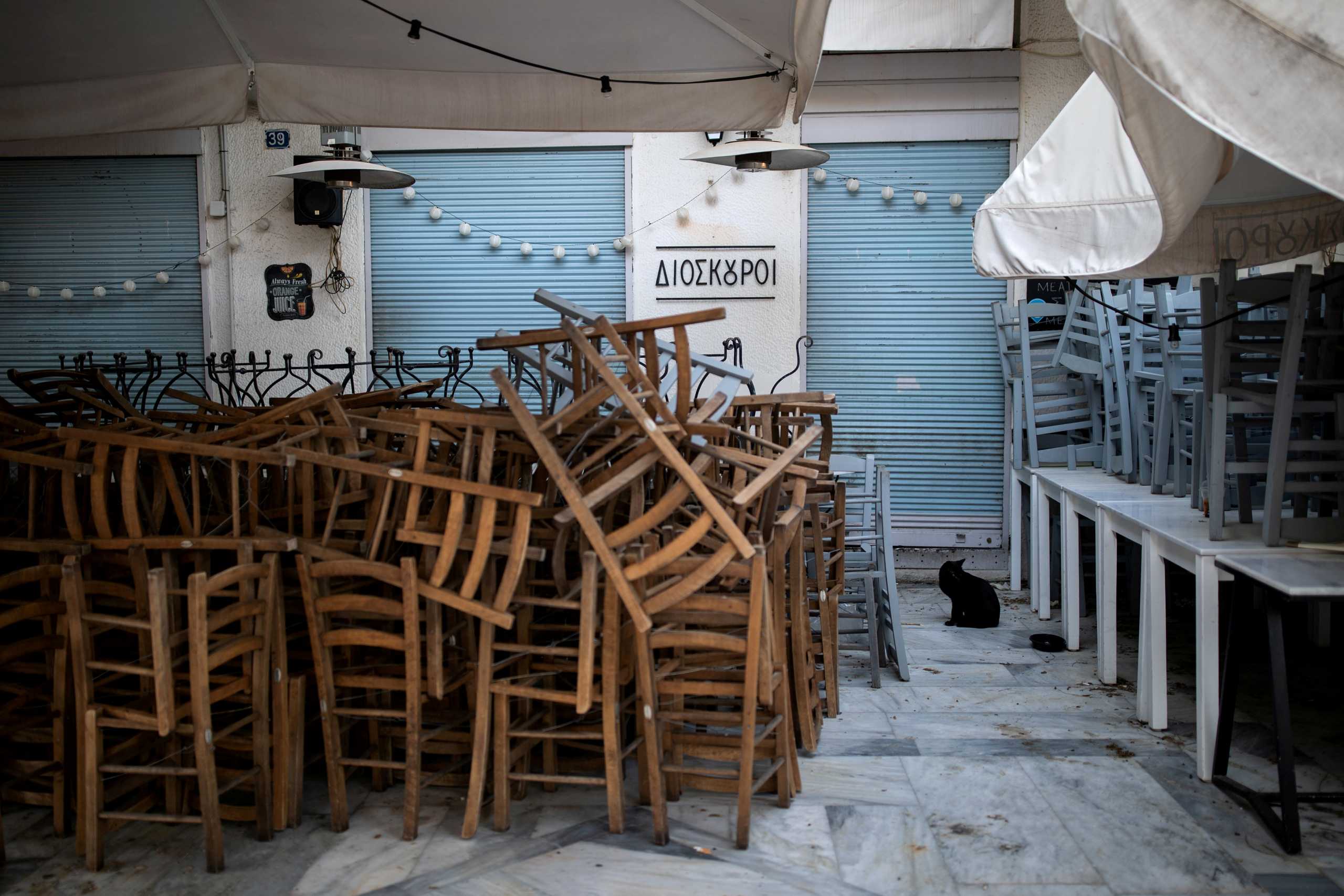 FILE PHOTO: A cat is seen next to piled up chairs in front of a closed restaurant in Thissio district, following the coronavirus disease (COVID-19) outbreak, in Athens, Greece, April 28, 2020. Picture taken April 28, 2020. REUTERS