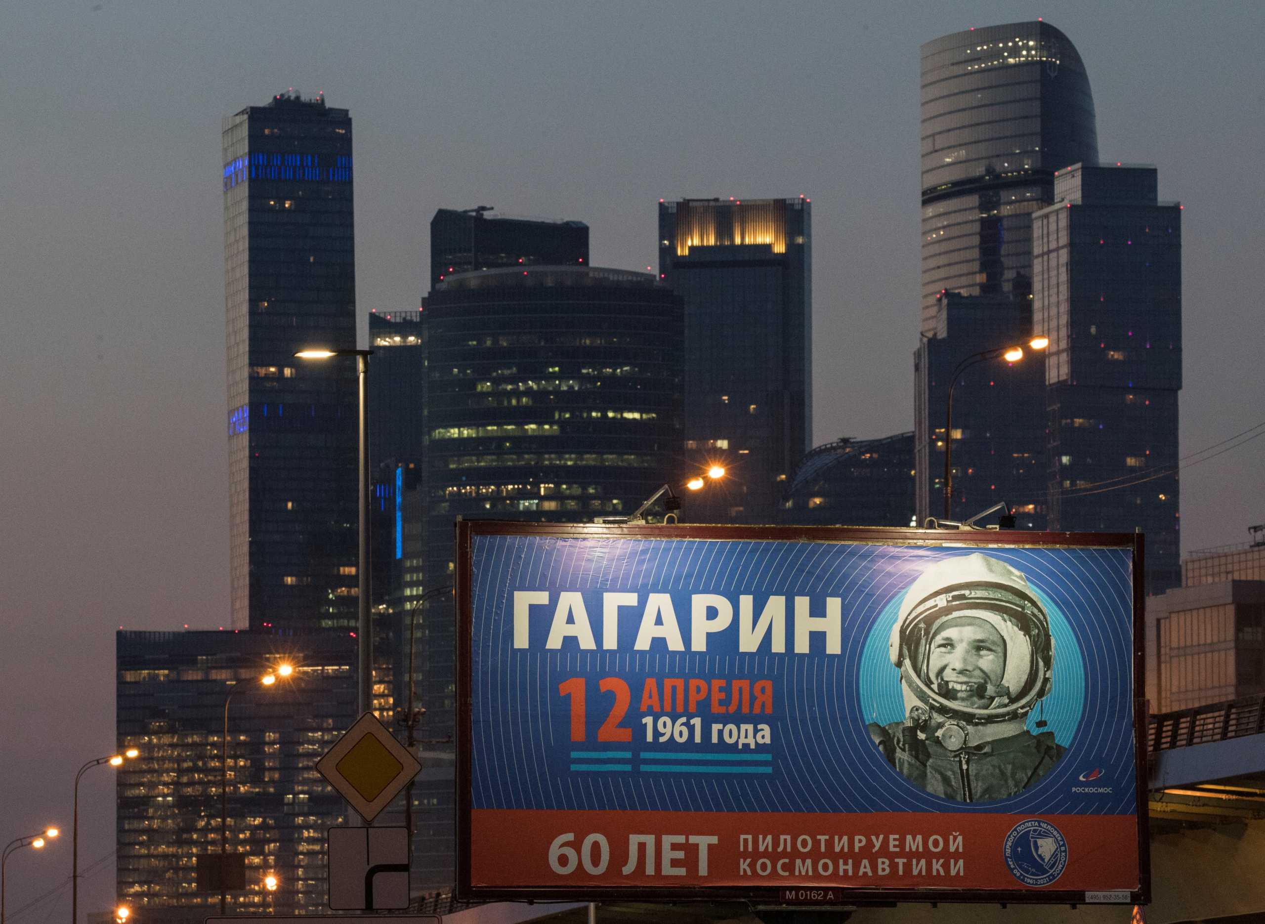 A board with Yuri Gagarin's portrait with backdrop of Moscow International Business Centre, also known as "Moskva-City", is seen on the eve of Cosmonautics Day, in Moscow, Russia April 11, 2021. The bottom sign reads "60 years of manned space exploration".  REUTERS