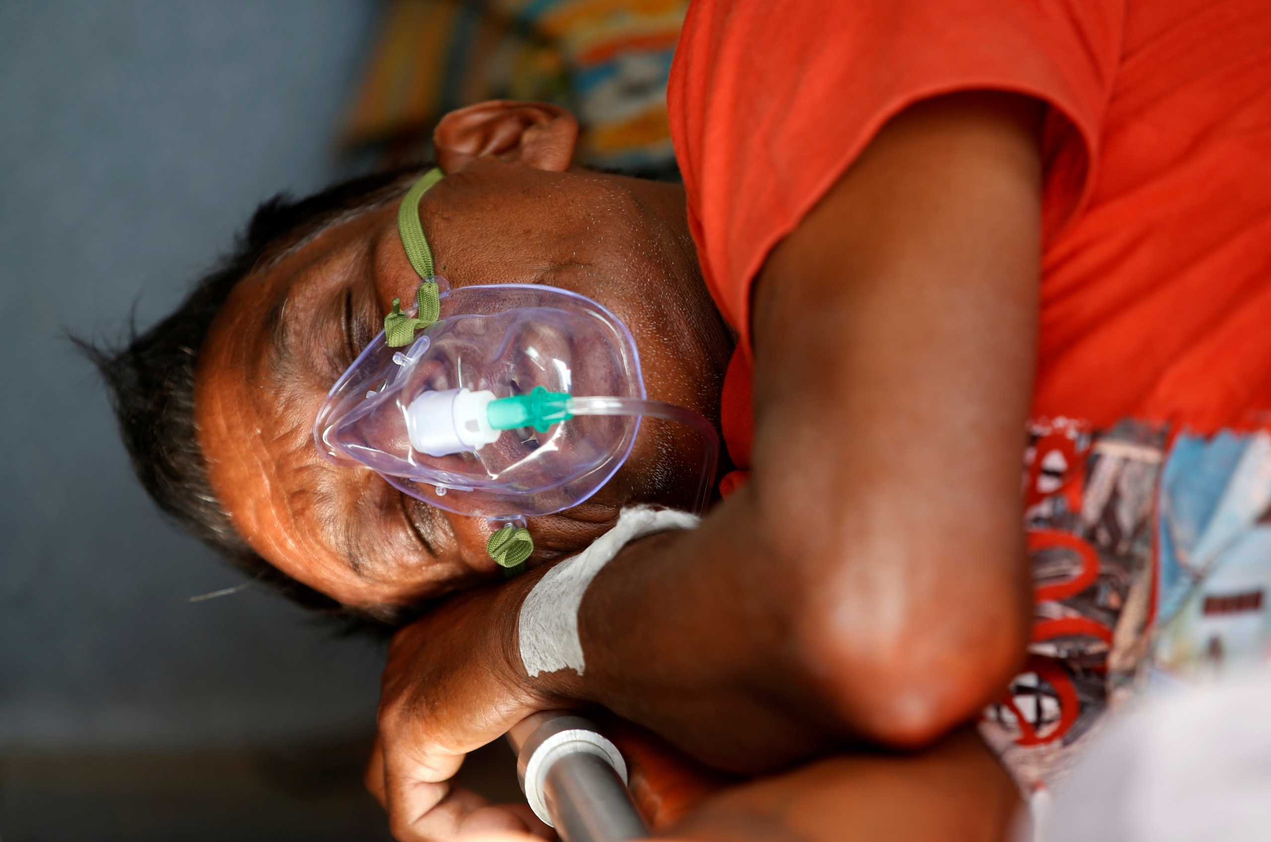 A patient wears an oxygen mask inside an ambulance waiting to enter a COVID-19 hospital for treatment, amidst the spread of the coronavirus disease (COVID-19) in Ahmedabad, India, April 21, 2021. REUTERS