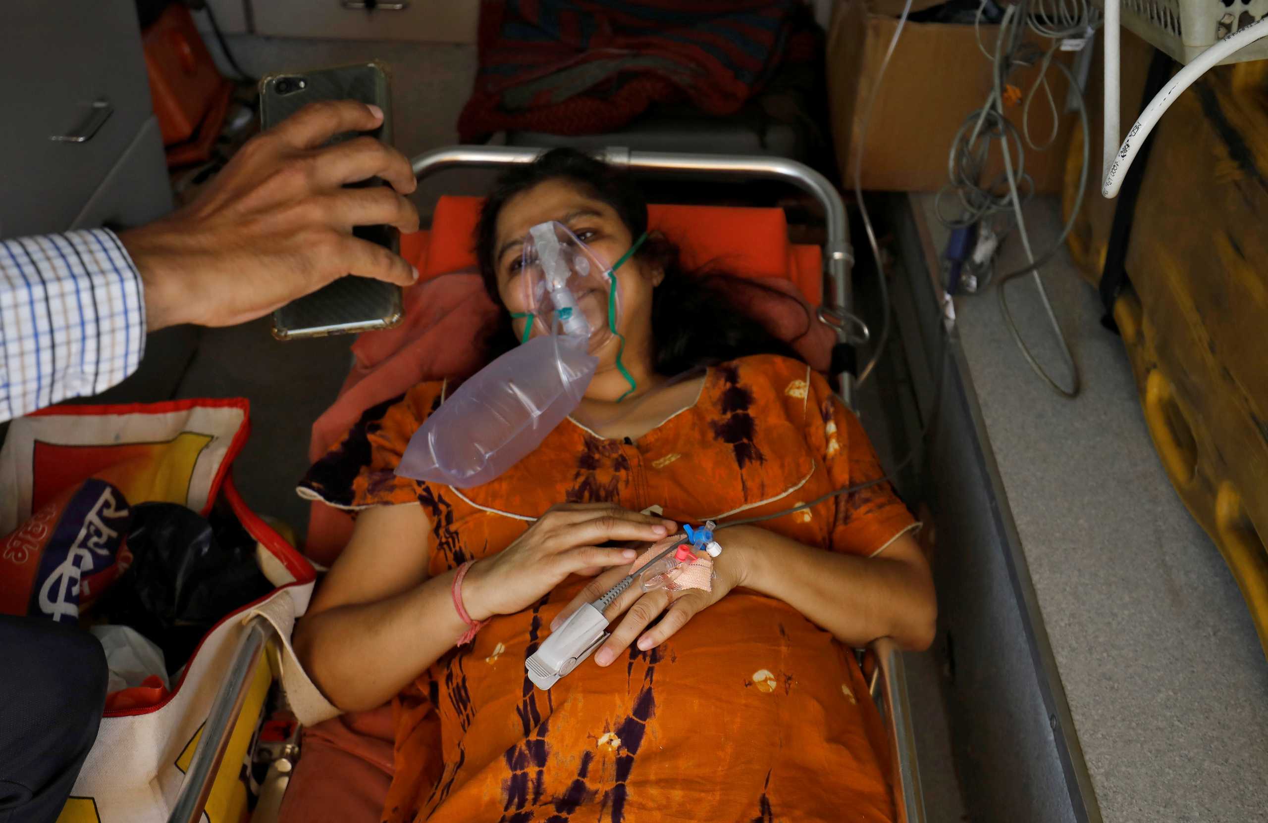 Madhuriben S Parmar reacts with an oxygen mask on as she speaks to her family on a video call while lying in an ambulance waiting to enter a COVID-19 hospital for treatment, amidst the spread of the coronavirus disease (COVID-19) in Ahmedabad, India, April 28, 2021. REUTERS