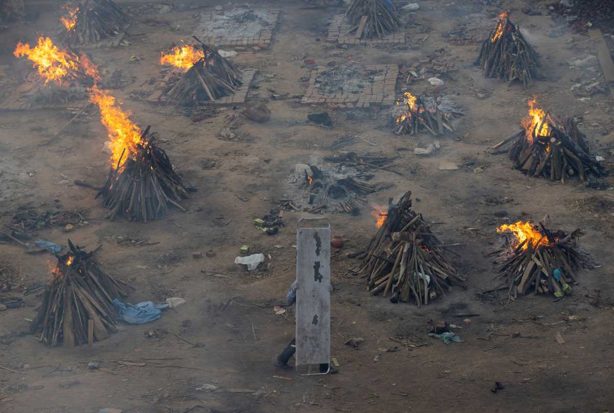 A man carries a stretcher used for carrying bodies of victims who died due to the coronavirus disease (COVID-19), during a mass cremation at a crematorium ground in New Delhi, India, April 23, 2021. REUTERS