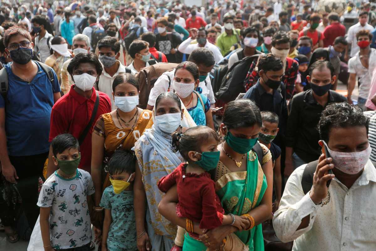 People wearing protective masks stand outside a railway station amidst the spread of the coronavirus disease (COVID-19), in Mumbai, India, April 13, 2021. REUTERS