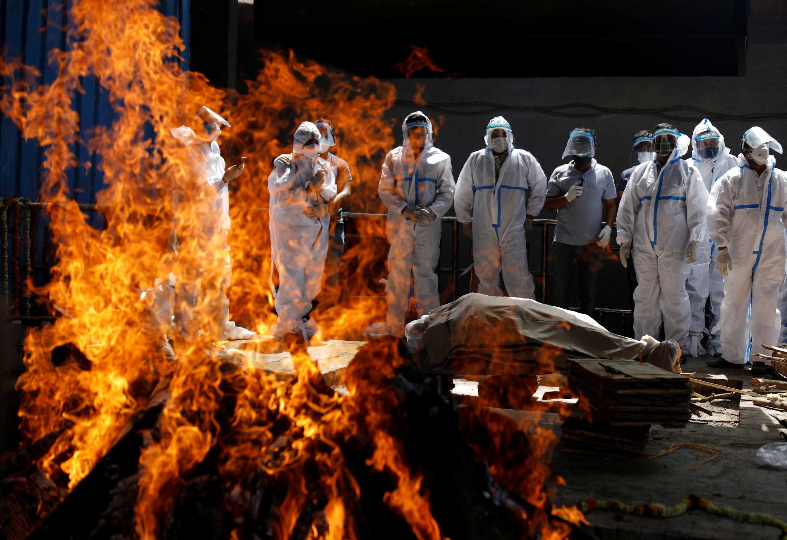 Relatives wearing personal protective equipment (PPE) attend the funeral of a man, who died from the coronavirus disease (COVID-19), at a crematorium in New Delhi, India April 21, 2021. REUTERS