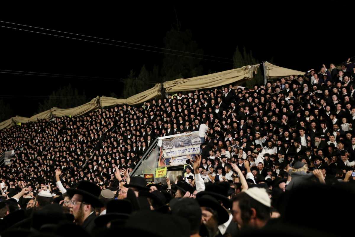 Jewish worshippers sing and dance as they stand on tribunes at the Lag B'Omer event in Mount Meron, northern Israel, April 29, 2021. REUTERS