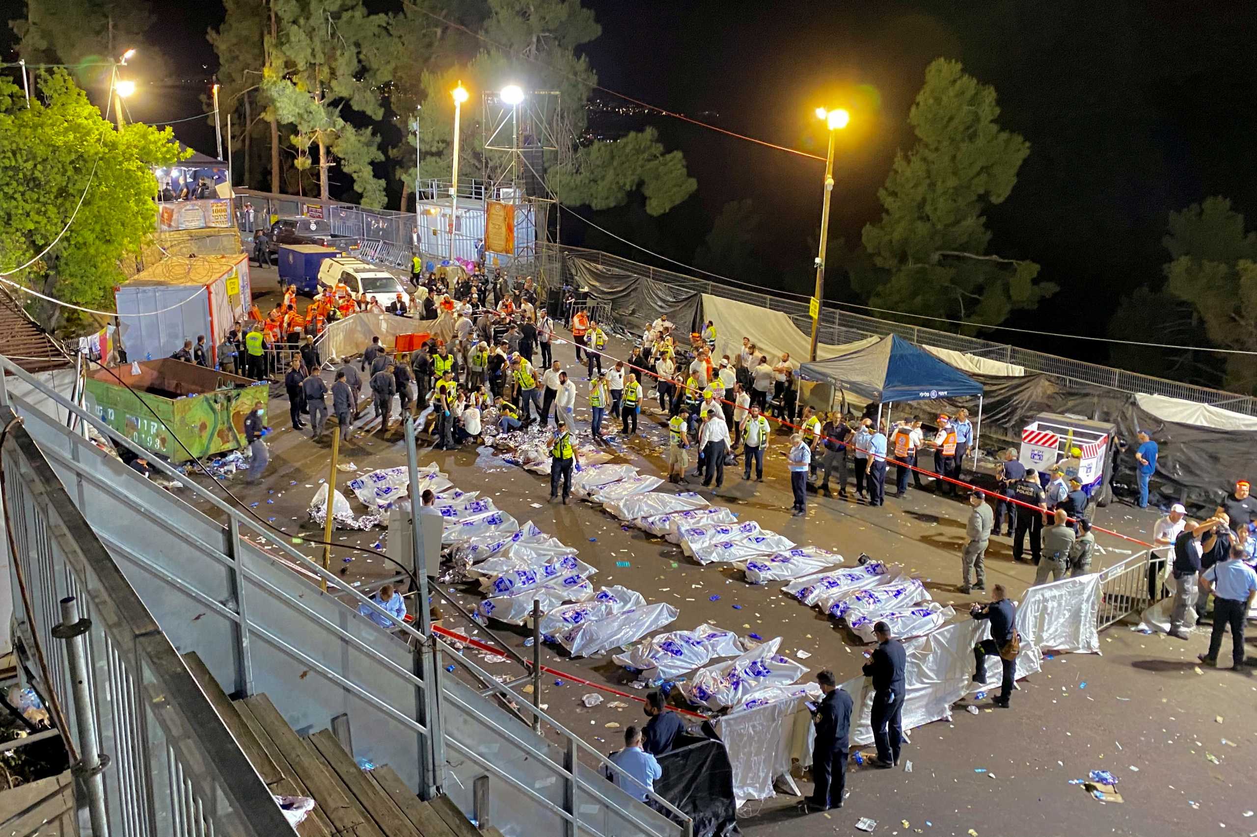 Rescue and medical personnel are seen next to covered dead bodies on Mount Meron where fatalities were reported among the thousands of ultra-Orthodox Jews gathered at the tomb of a 2nd-century sage for annual commemorations that include all-night prayer and dance, April 30, 2021. REUTERS
