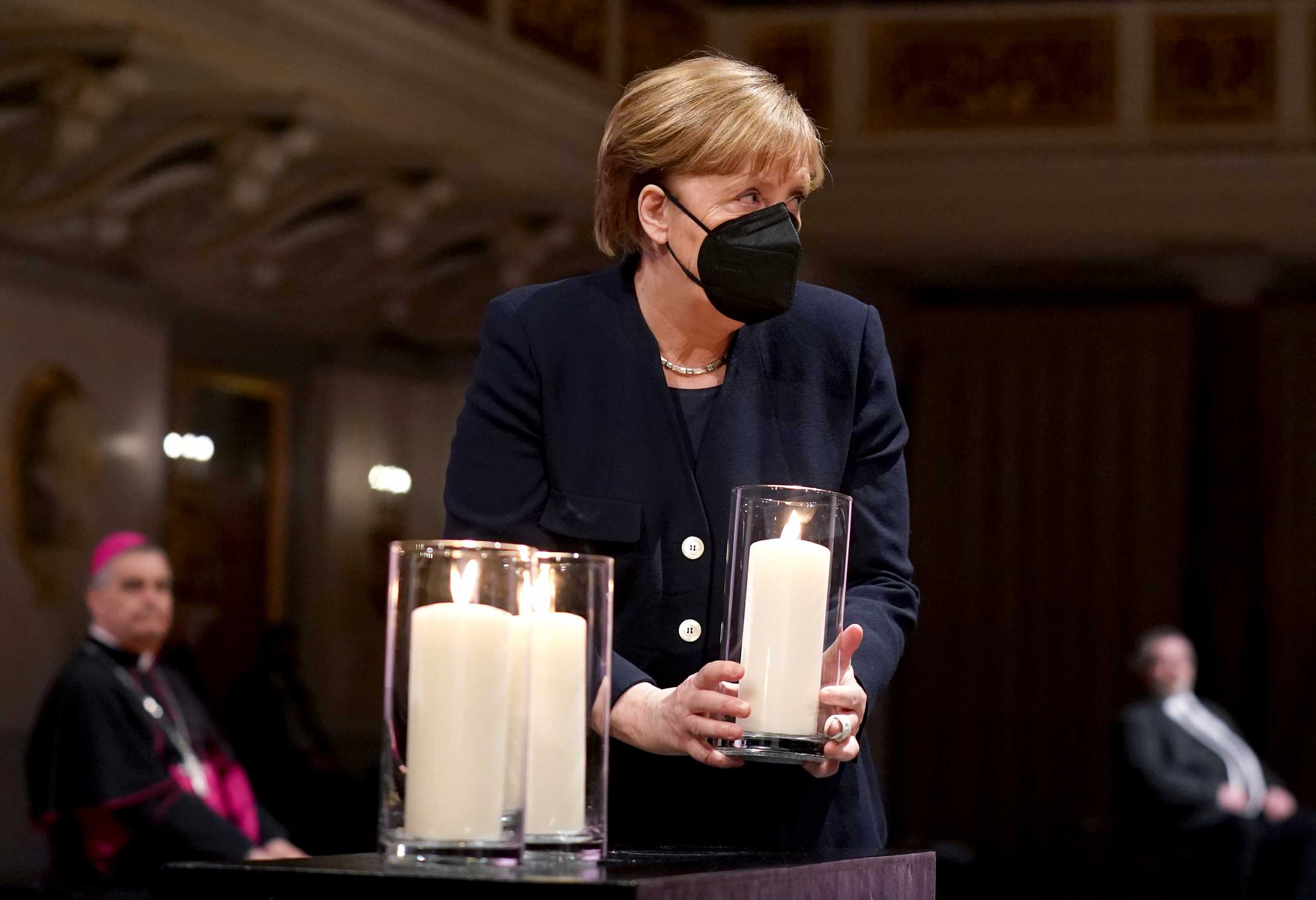 German Chancellor Angela Merkel holds a candle during a memorial ceremony for the victims of coronavirus disease (COVID-19) pandemic, in Berlin, Germany April 18, 2021. Michael Sohn