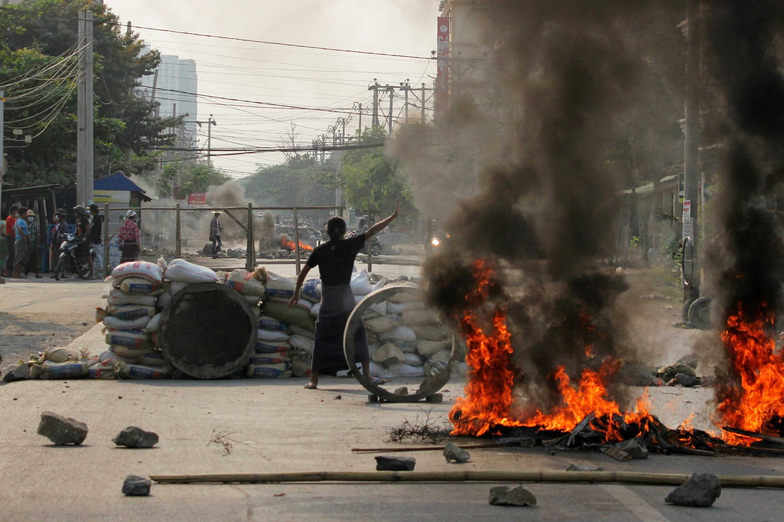 FILE PHOTO: A demonstrator gestures near a barricade during a protest against the military coup in Mandalay, Myanmar March 22, 2021. REUTERS