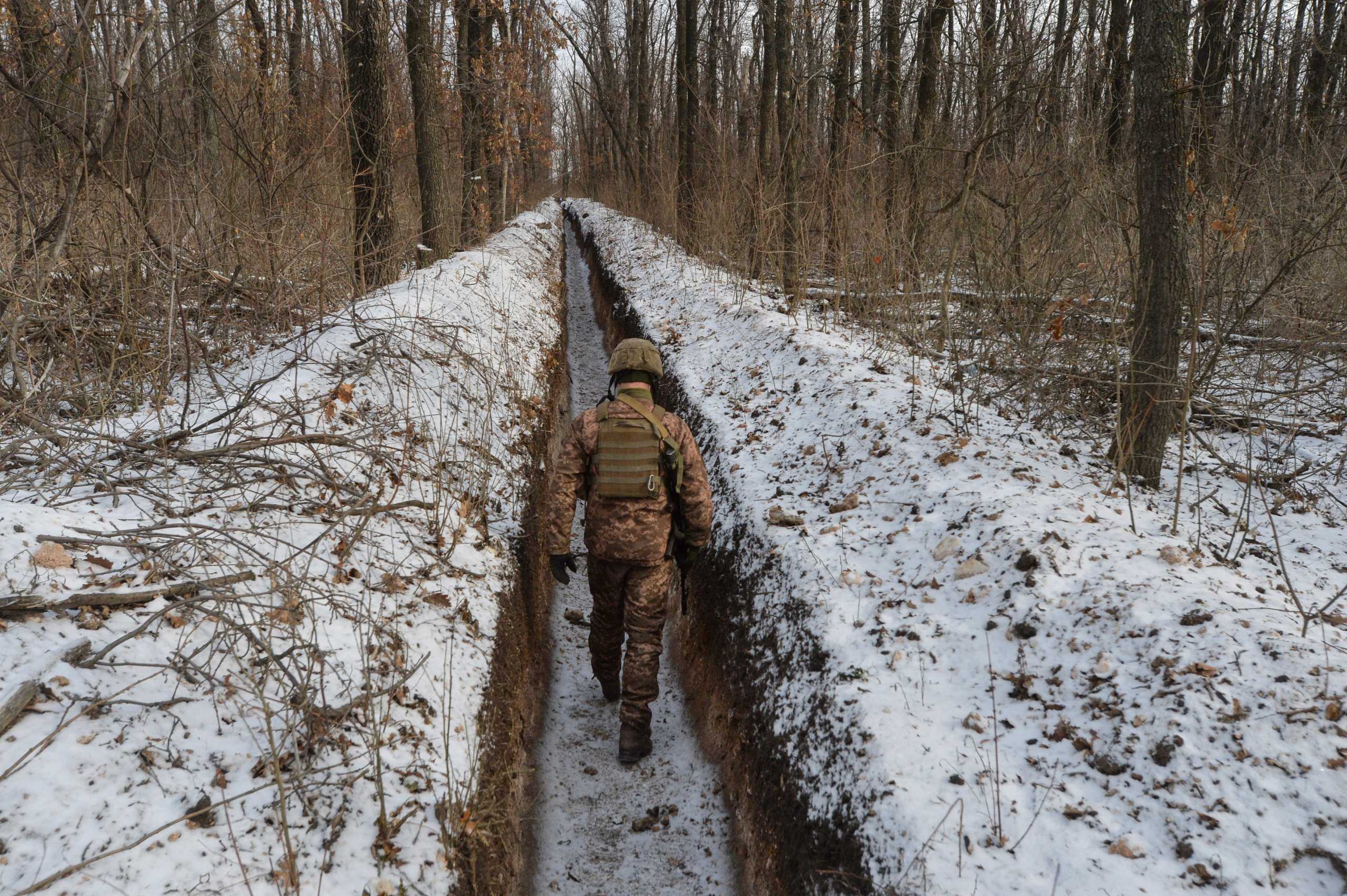 FILE PHOTO: A Ukrainian service member walks along fighting positions on the contact line with Russian-backed separatist rebels near the town of Avdiivka in Donetsk Region, Ukraine February 13, 2021. Picture taken February 13, 2021. REUTERS