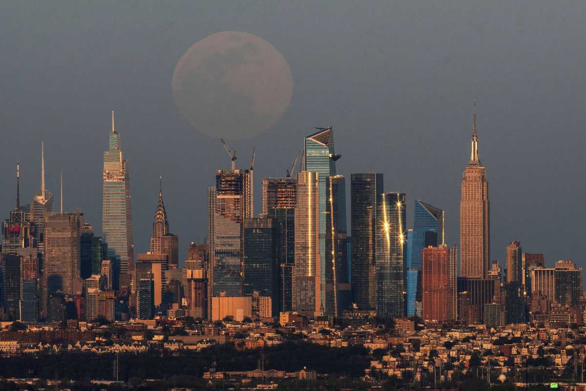 The full moon, known as the "Super Pink Moon", rises over the skyline of New York and Empire State Building, as seen from West Orange, in New Jersey, U.S. April 26, 2021. REUTERS