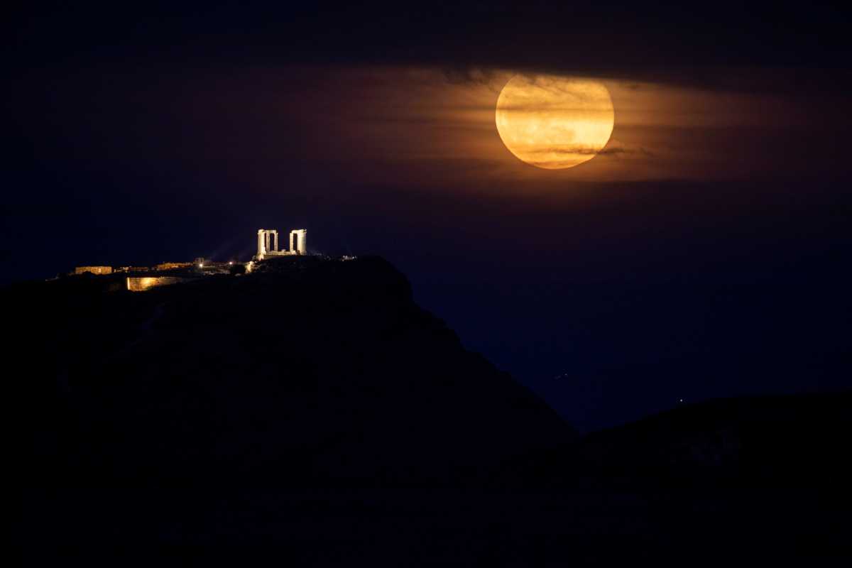 The full moon, known as the "Super Pink Moon" rises next to the Temple of Poseidon in Cape Sounion, near Athens, Greece, April 27, 2021. REUTERS