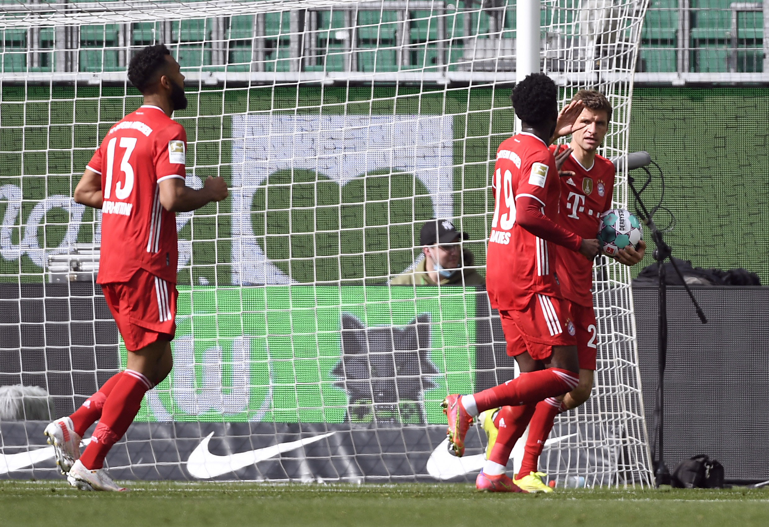 Soccer Football - Bundesliga - VfL Wolfsburg v Bayern Munich - Volkswagen Arena, Wolfsburg, Germany - April 17, 2021  Bayern Munich's Thomas Muller and Alphonso Davies celebrate after Jamal Musiala scores their first goal Pool via REUTERS