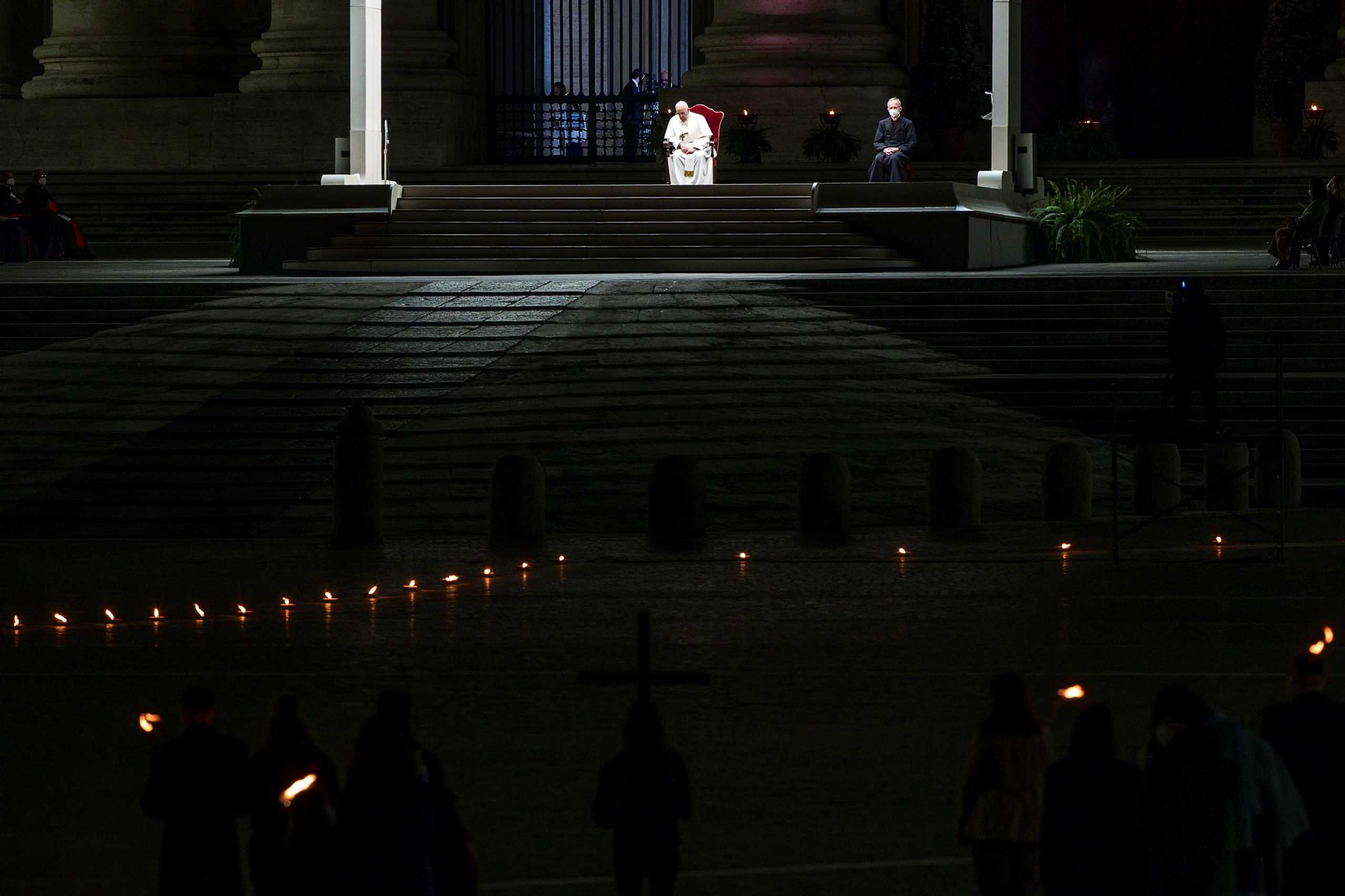 Pope Francis leads the Via Crucis (Way of the Cross) procession in the empty square outside the Saint Peter's Basilica during Good Friday celebrations at the Vatican, April 2, 2021. Angelo Carconi