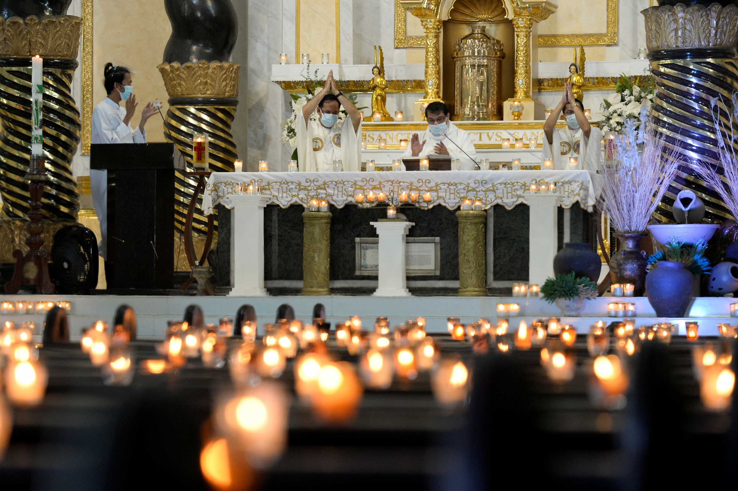 Catholic priests wearing face masks as a protection against the coronavirus disease (COVID-19), attend an Easter Sunday Mass at the St. Peter Parish Shrine of Leaders, in Quezon City, Metro Manila, Philippines, April 4, 2021. REUTERS