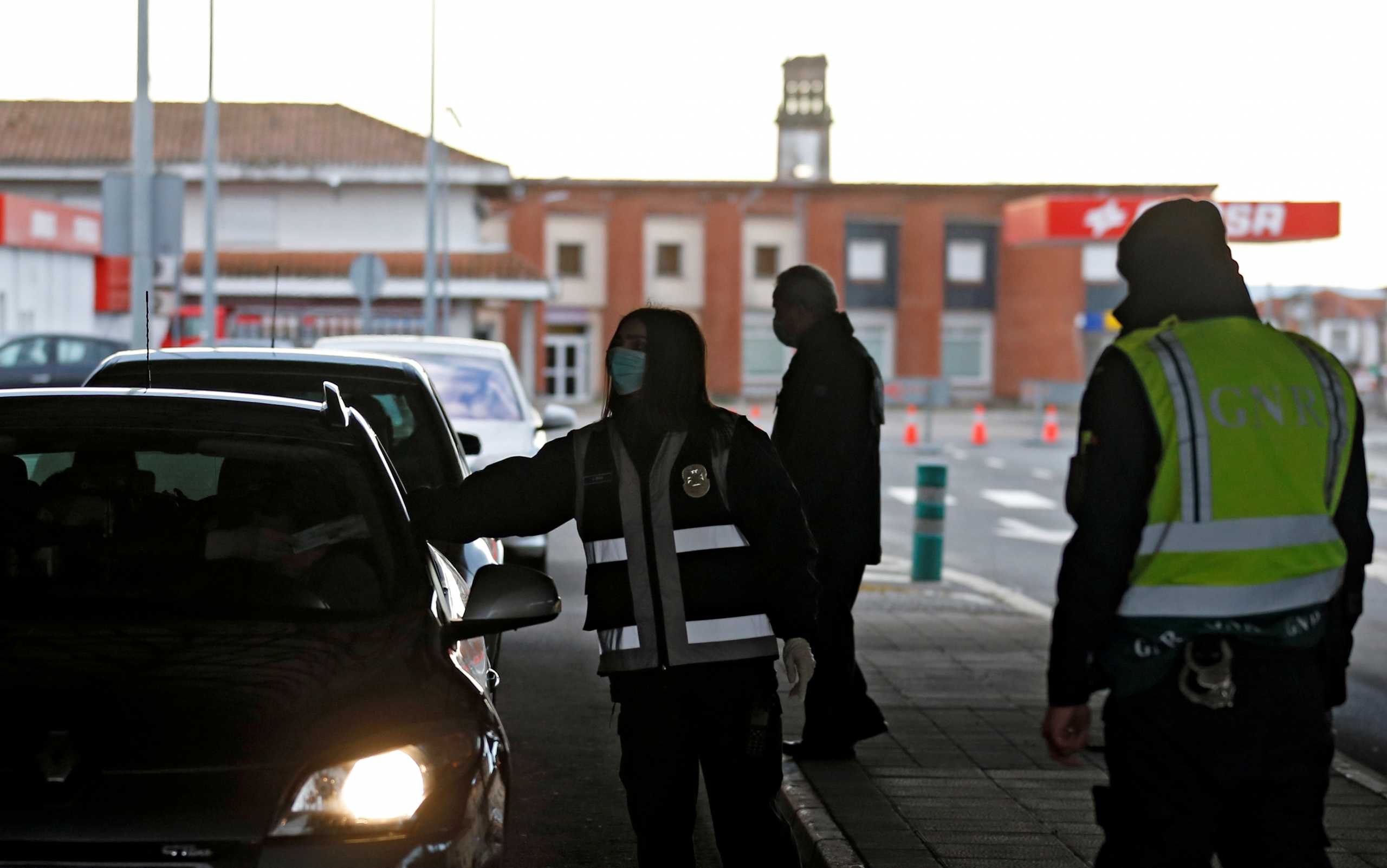 FILE PHOTO: Portuguese police officers check a car at the border between Portugal and Spain, following an order from the Spanish government to set up controls at its land borders over coronavirus, in Vilar Formoso, Portugal, March 17, 2020. REUTERS