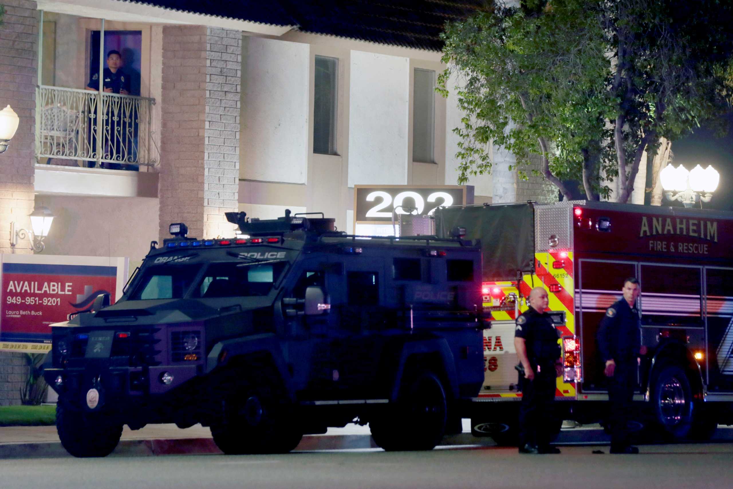 City of Orange police officers stand in front of a building after a shooting in Orange, California, U.S. March 31, 2021.   REUTERS