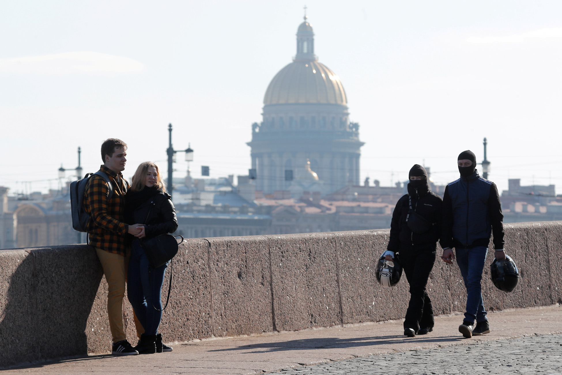 FILE PHOTO: People rest on the Spit of Vasilievsky Island with the St. Isaac's Cathedral in the background on the first day of holidays ordered by President Vladimir Putin to curb the spread of the coronavirus disease (COVID-19), in central Saint Petersburg, Russia March 28, 2020.  REUTERS