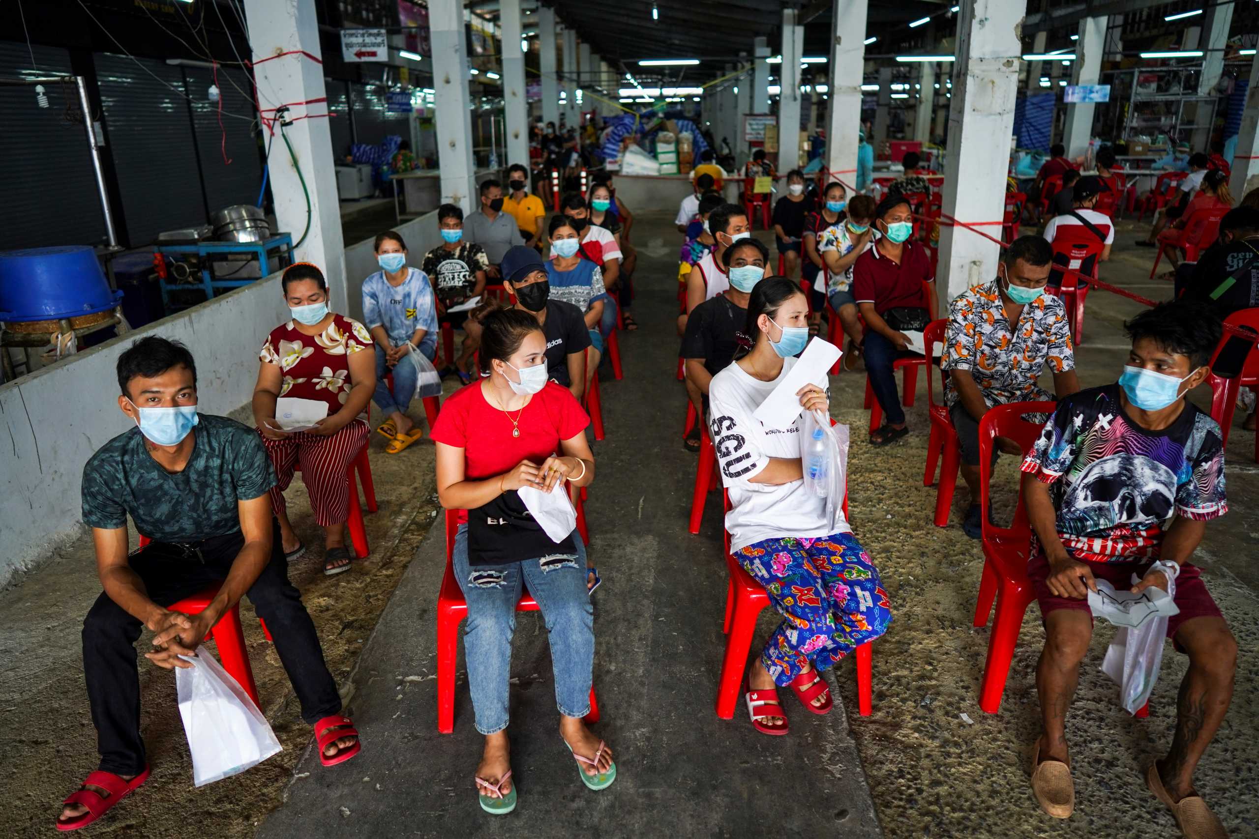 People wait to receive the Sinovac coronavirus disease (COVID-19) vaccine at a market after hundreds of local residents in the district tested positive for COVID-19 in Bangkok, Thailand, March 17, 2021. REUTERS