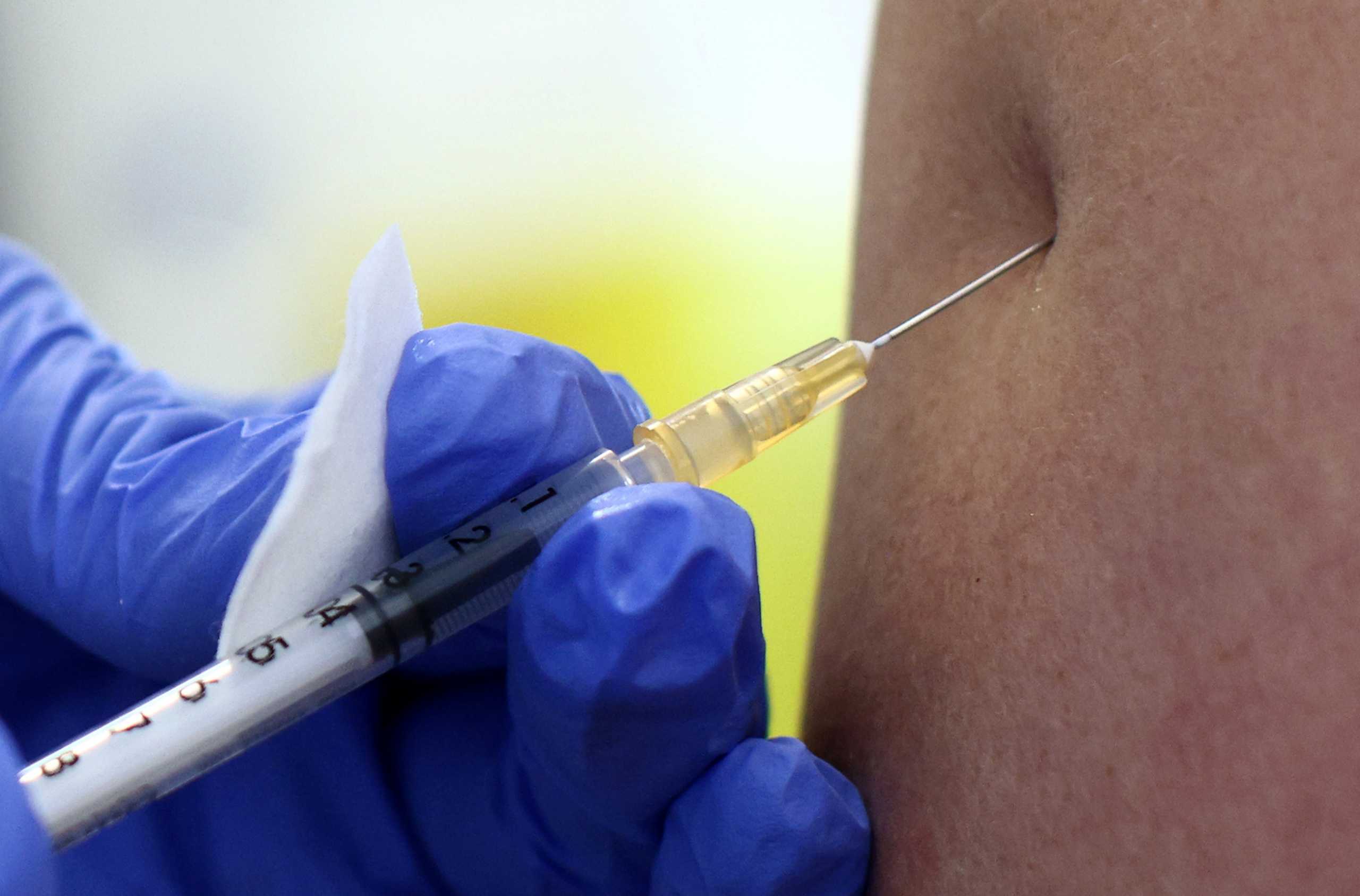 A person receives a dose of the Pfizer-BioNTech COVID-19 vaccine inside a container to use for general practitioners, called 'vaccination box' in Vienna, Austria April 26, 2021. REUTERS