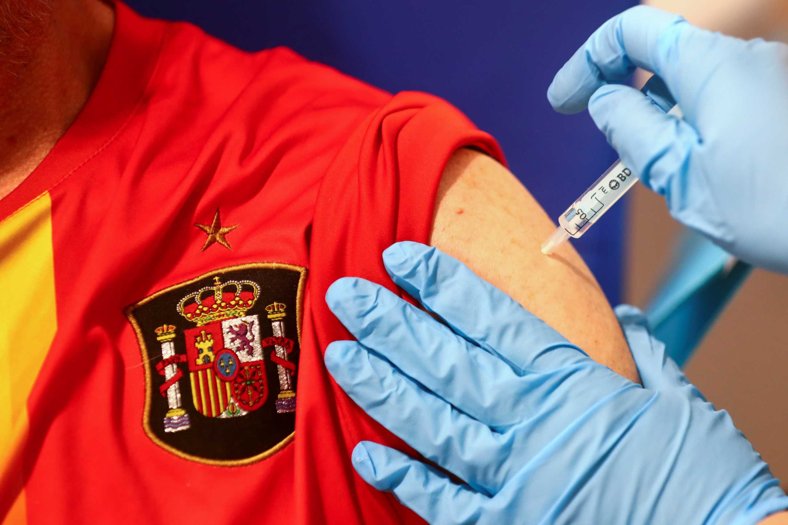 A man, wearing a t-shirt with the logo of Spanish National soccer team, receives his first dose of the AstraZeneca COVID-19 vaccine, as the coronavirus disease (COVID-19) outbreak continues, at Enfermera Isabel Zendal hospital in Madrid, Spain, April 6, 2021. REUTERS