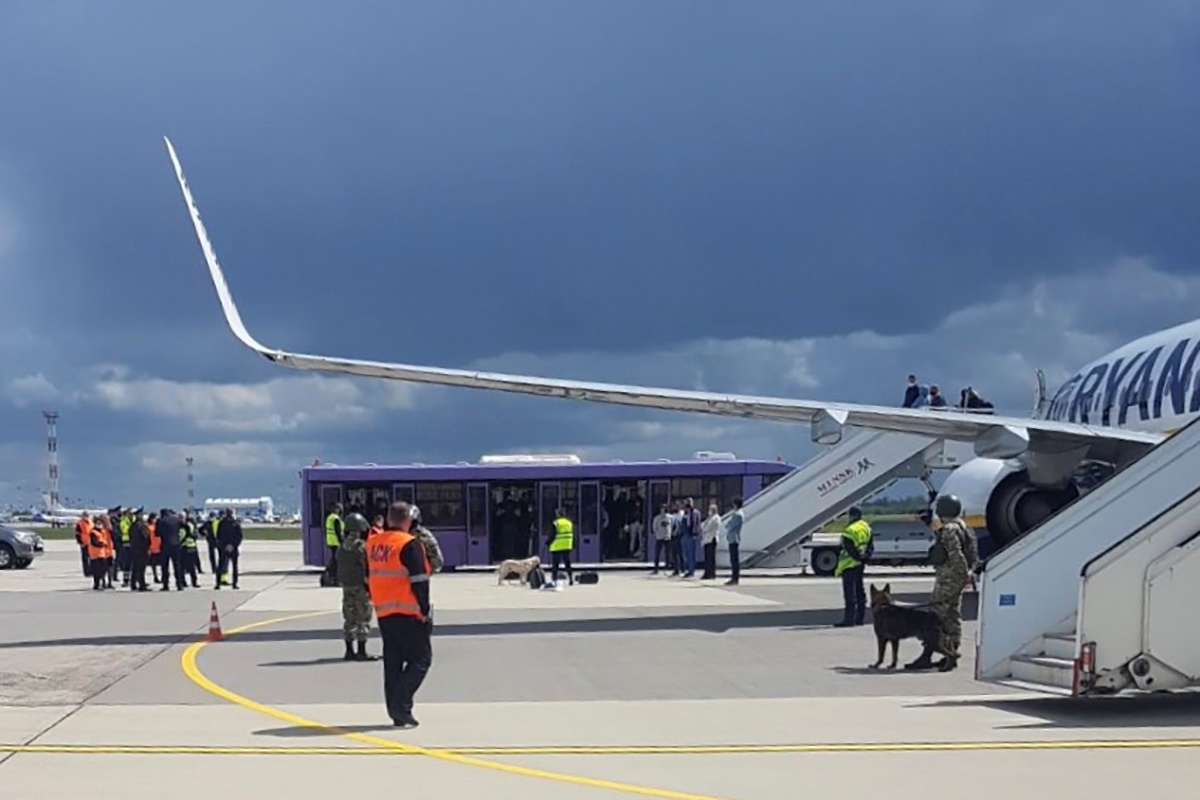 Airport personnel and security forces are seen on the tarmac in front of a Ryanair flight which was forced to land in Minsk, Belarus, May 23, 2021. Picture taken May 23, 2021. Handout via REUTERS ATTENTION EDITORS - THIS PICTURE WAS PROVIDED BY A THIRD PARTY.