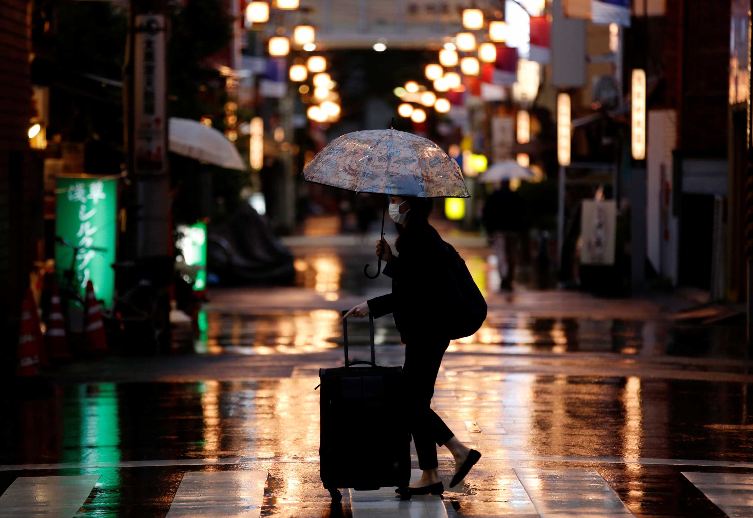 A woman wearing a protective face mask, amid the coronavirus disease (COVID-19) pandemic, walks in a local shopping street in Tokyo, Japan, May 7, 2021. REUTERS