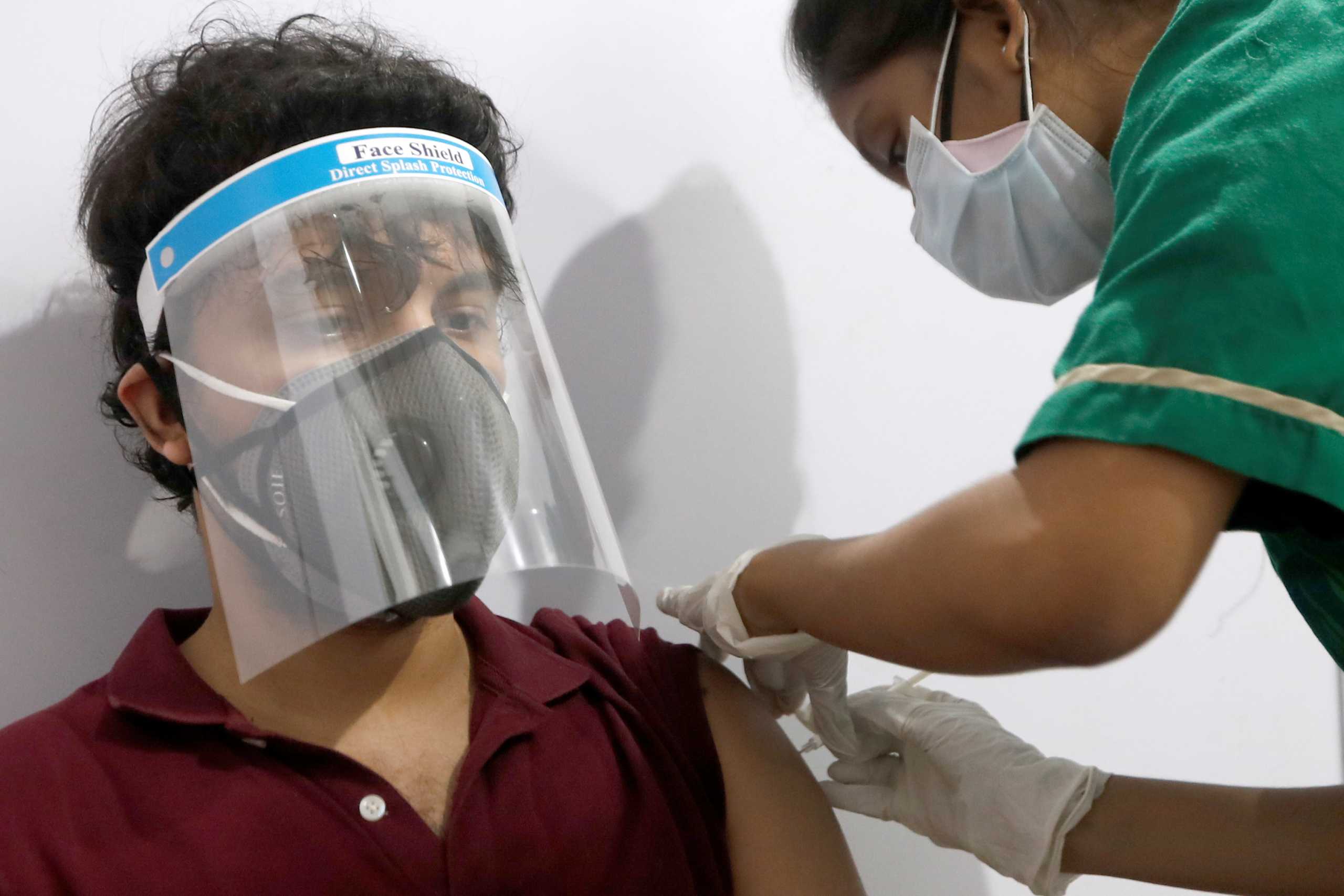 A man wearing a face shield receives a dose of COVISHIELD, a coronavirus disease (COVID-19) vaccine manufactured by Serum Institute of India, at a vaccination centre in Mumbai, India, May 1, 2021. REUTERS