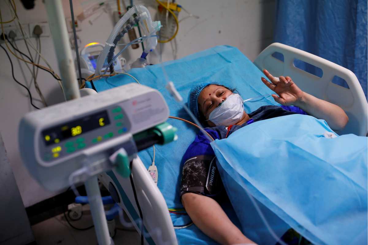 Geetika, 45, who is suffering from coronavirus disease (COVID-19), gestures as a Syringe Infusion Pump, donated by France is seen next to her bed, inside the emergency room of Safdarjung Hospital in New Delhi, India, May 7, 2021. REUTERS