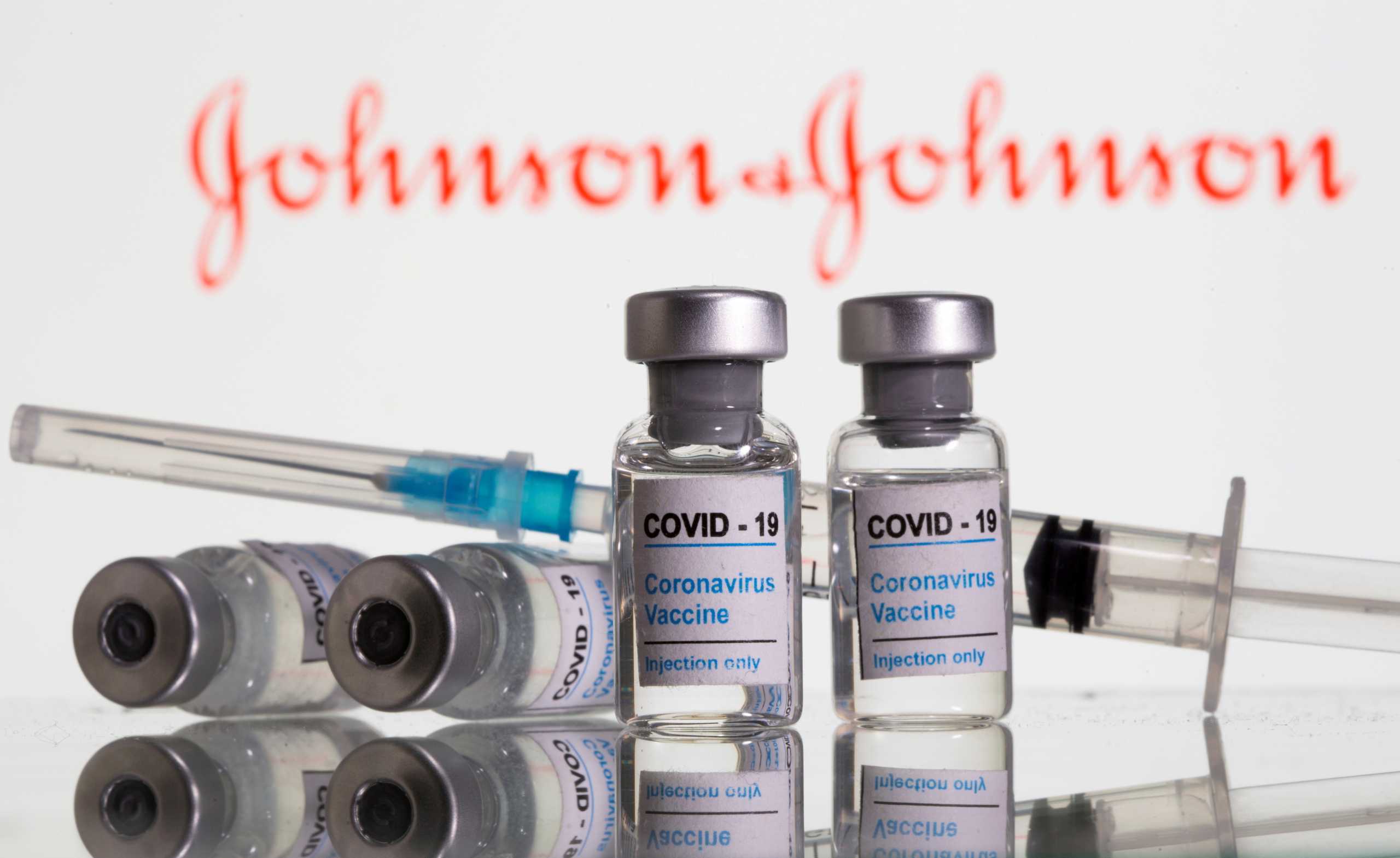 FILE PHOTO: Vials labeled "COVID-19 Coronavirus Vaccine" and syringe are seen in front of displayed Johnson&Johnson logo in this illustration taken, February 9, 2021. REUTERS