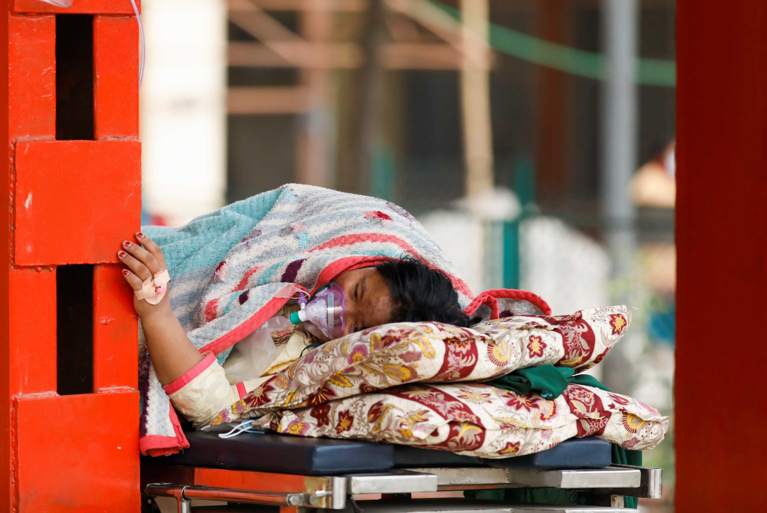 A patient receives oxygen as she waits outside the passage of a hospital due to a lack of free beds inside the hospital for coronavirus disease (COVID-19) patients, as the second major coronavirus wave surges in Kathmandu, Nepal, May 10, 2021. REUTERS