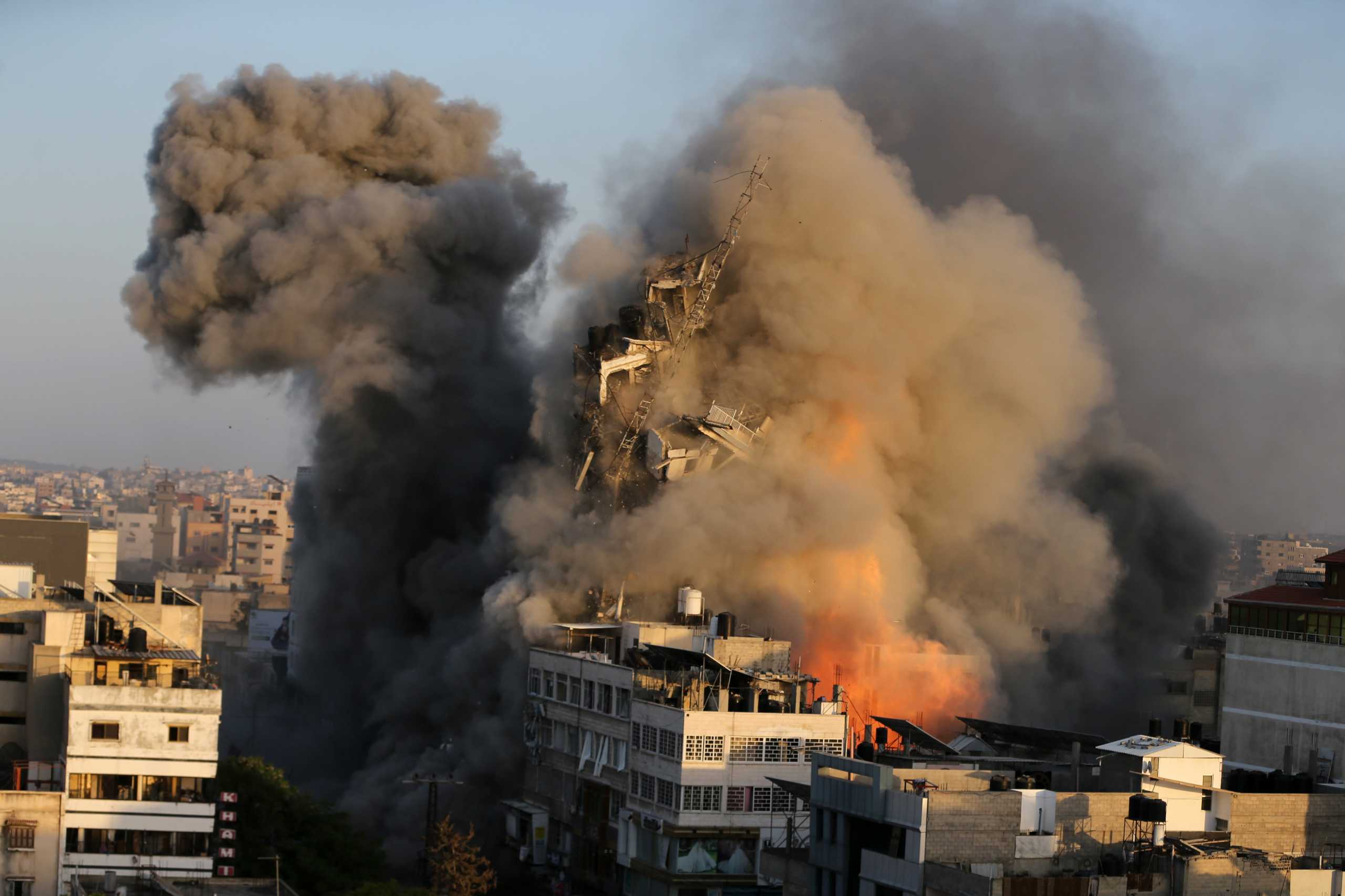 Smoke rises as a tower building collapses after it was hit by Israeli air strikes amid a flare-up of Israeli-Palestinian violence, in Gaza City May 12, 2021. REUTERS