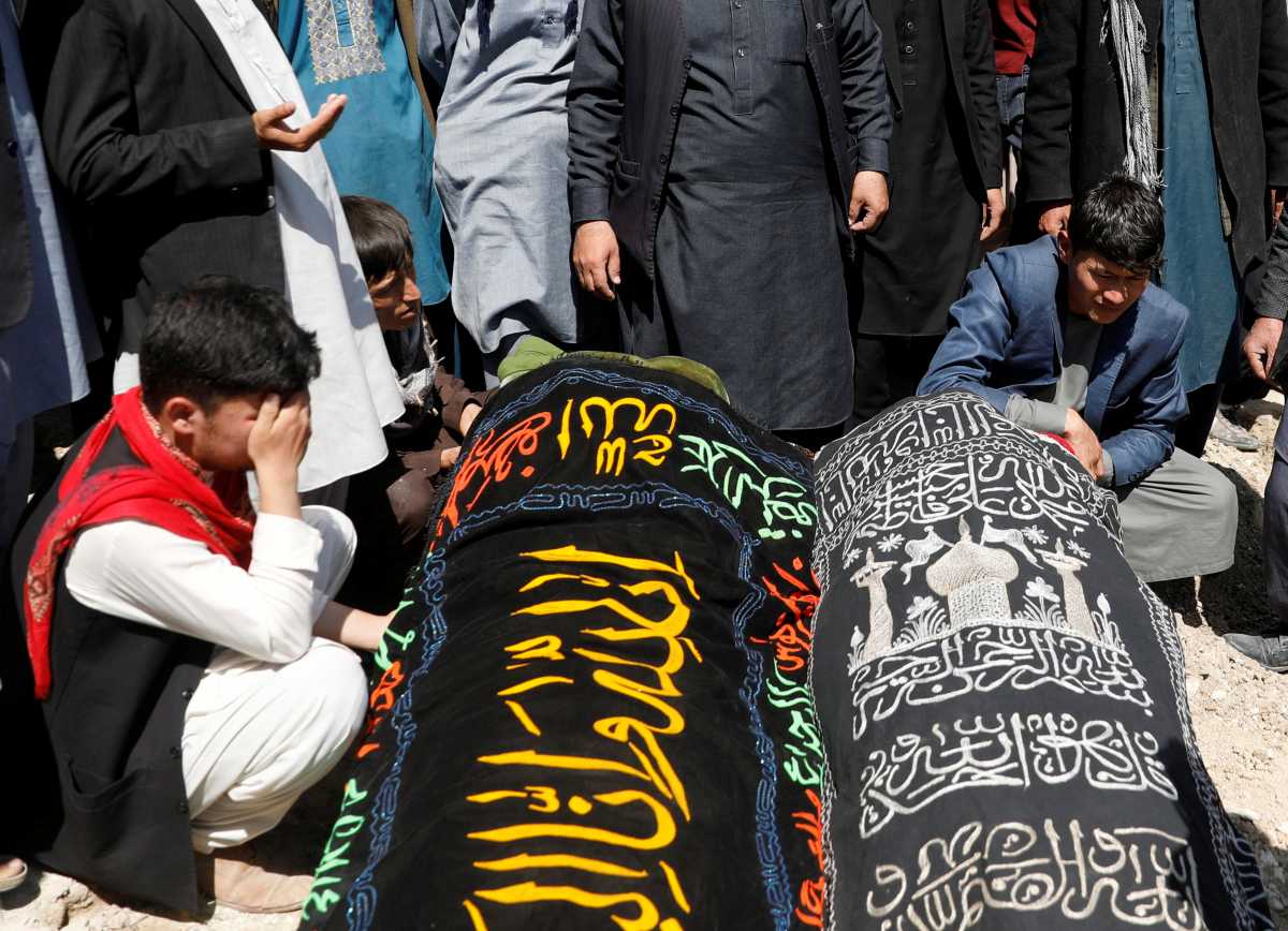 Relatives mourn next to coffins of two victims of yesterday's explosion during a mass funeral ceremony in Kabul, Afghanistan May 9, 2021. REUTERS