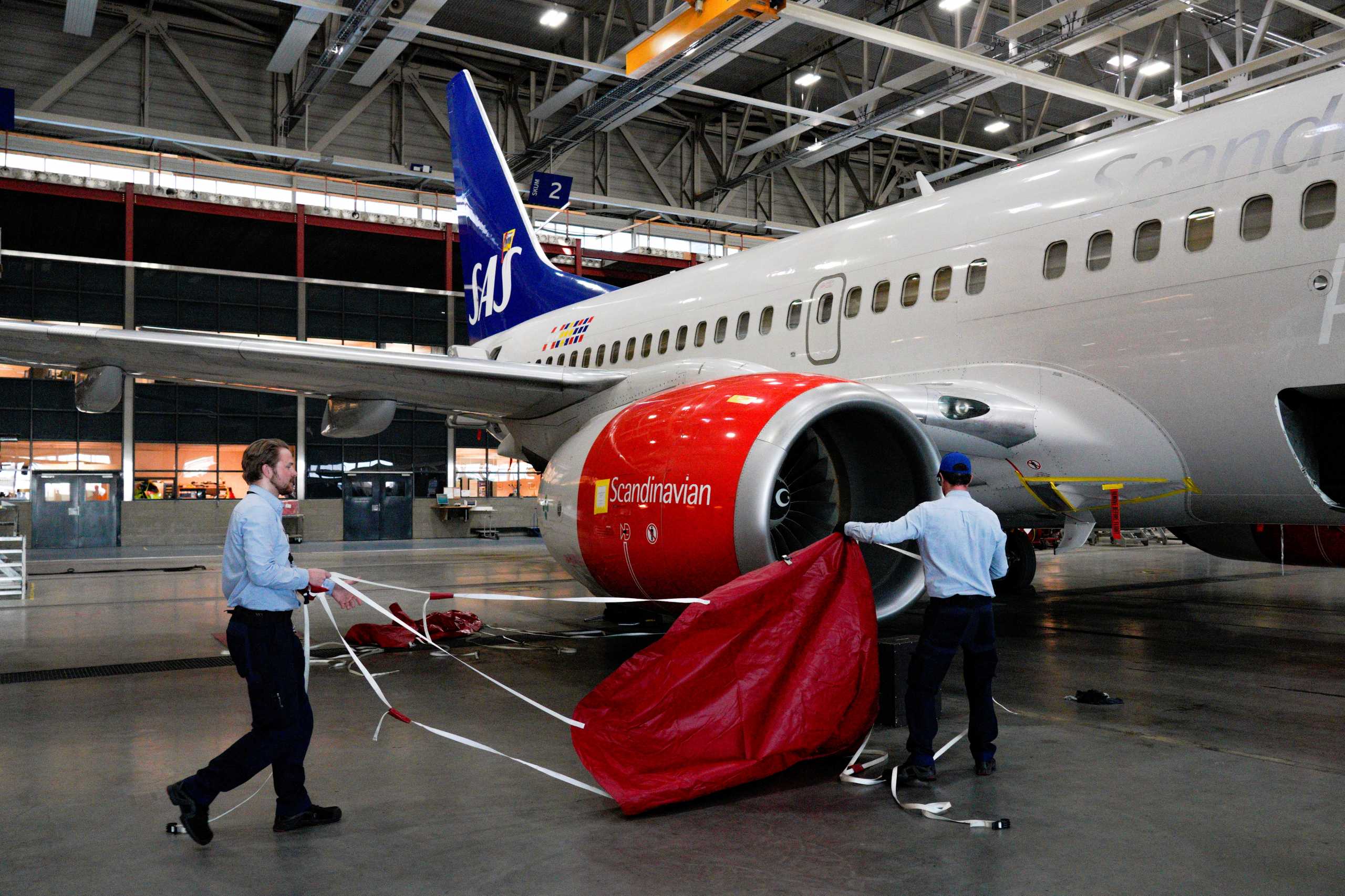FILE PHOTO: Flight technicians Henrik Sorensen Storsveen and Martin Markussen prepare the last of 25 Scandinavian Airlines System (SAS) aircrafts for long-term parking, amid the coronavirus disease (COVID-19) spread, at Oslo Airport Gardermoen. NTB Scanpix