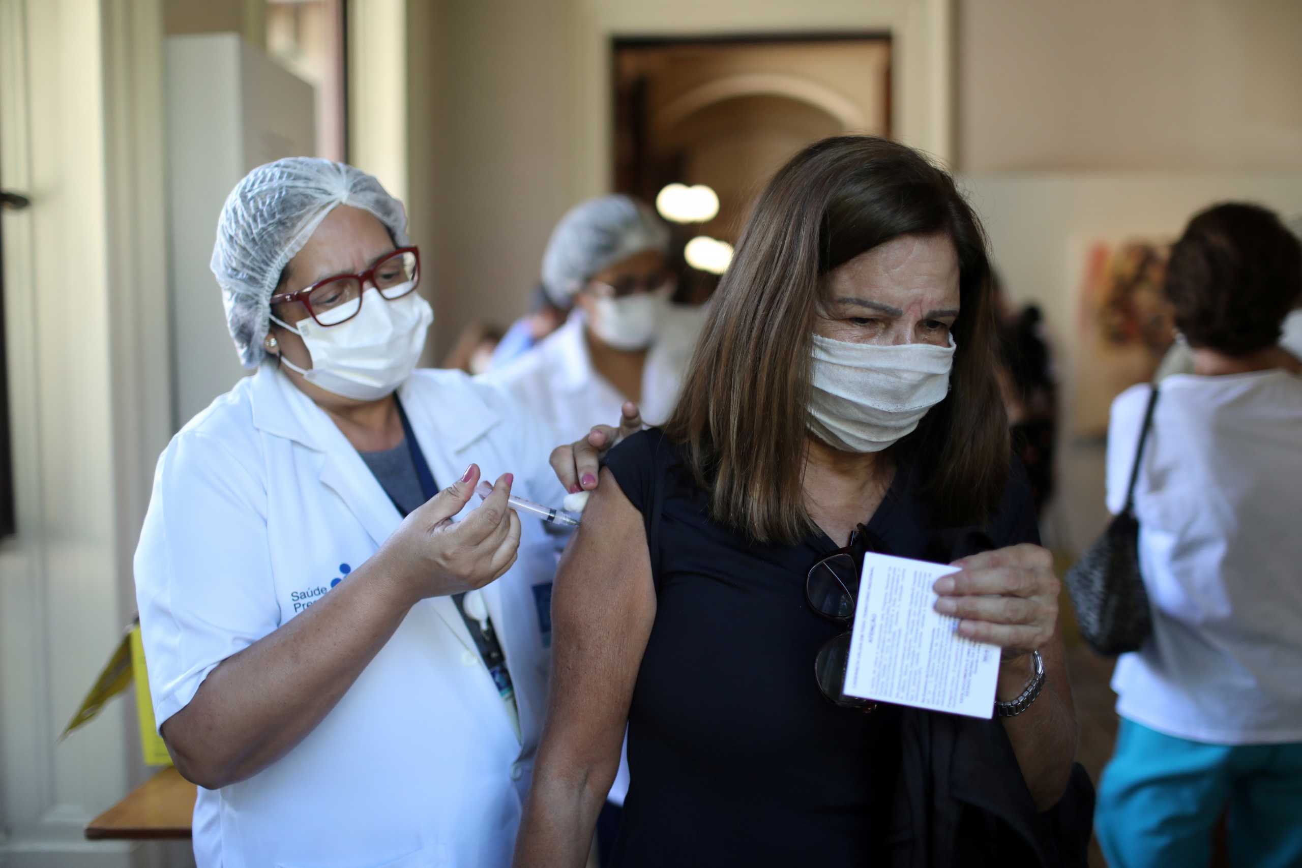 FILE PHOTO: A woman receives the Oxford-AstraZeneca coronavirus disease (COVID-19) vaccine, at the Catete Palace in Rio de Janeiro, Brazil April 23, 2021. REUTERS