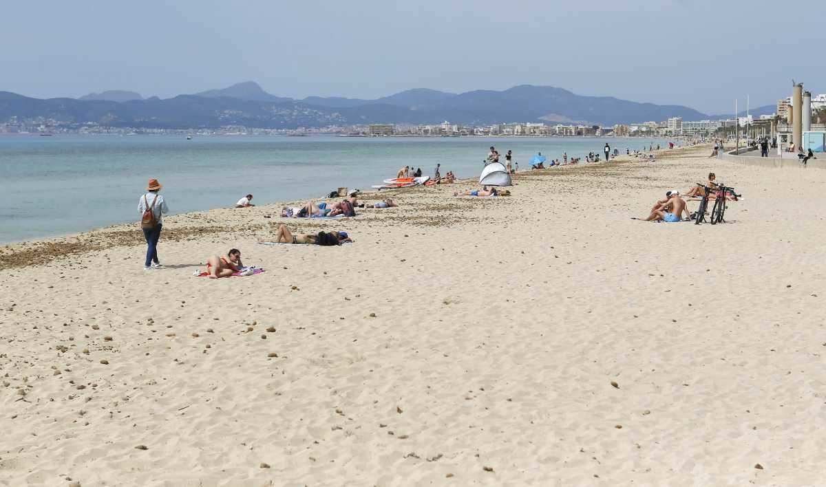 FILE PHOTO: People sunbathe and chill on Playa de Palma beach in Palma de Mallorca, Spain, April 1, 2021. REUTERS