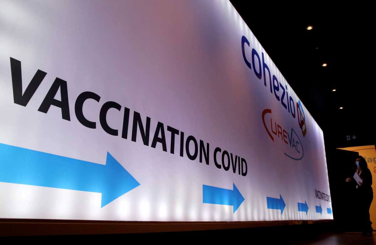 FILE PHOTO: A woman walks past a board in a testing center for the CureVac vaccine during a study by the German biotech firm CureVac as part of a testing for a new vaccine against the coronavirus disease (COVID-19), in Brussels, Belgium March 2, 2021. REUTERS