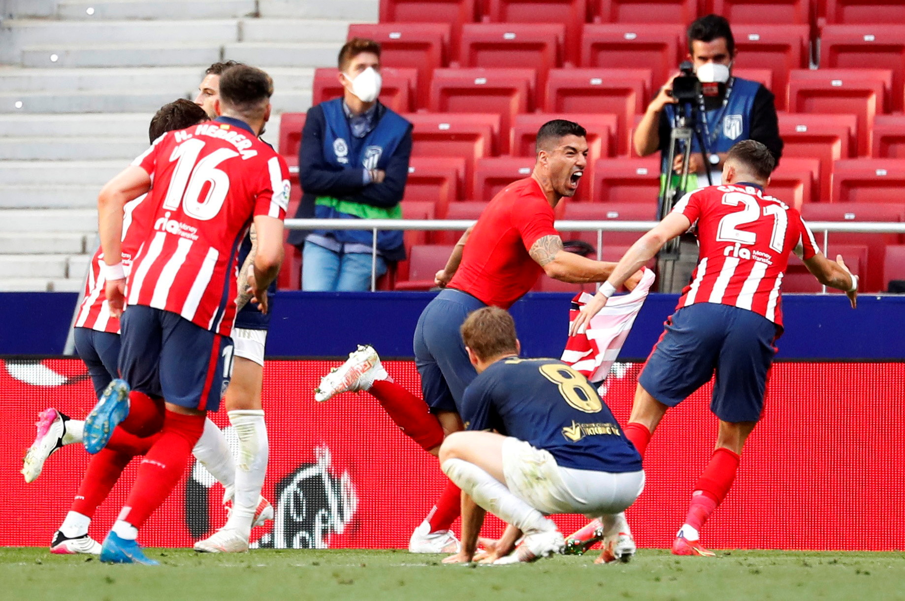 Soccer Football - La Liga Santander - Atletico Madrid v Osasuna - Wanda Metropolitano, Madrid, Spain - May 16, 2021 Atletico Madrid's Luis Suarez celebrates scoring their second goal with teammates as Osasuna players look dejected REUTERS