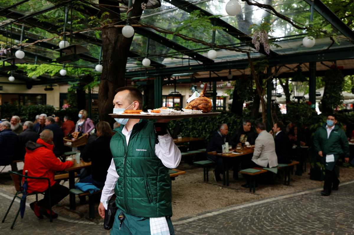 A server carries a tray with food in a beer garden as the coronavirus disease (COVID-19) restrictions continue to ease, in Vienna, Austria May 19, 2021. REUTERS