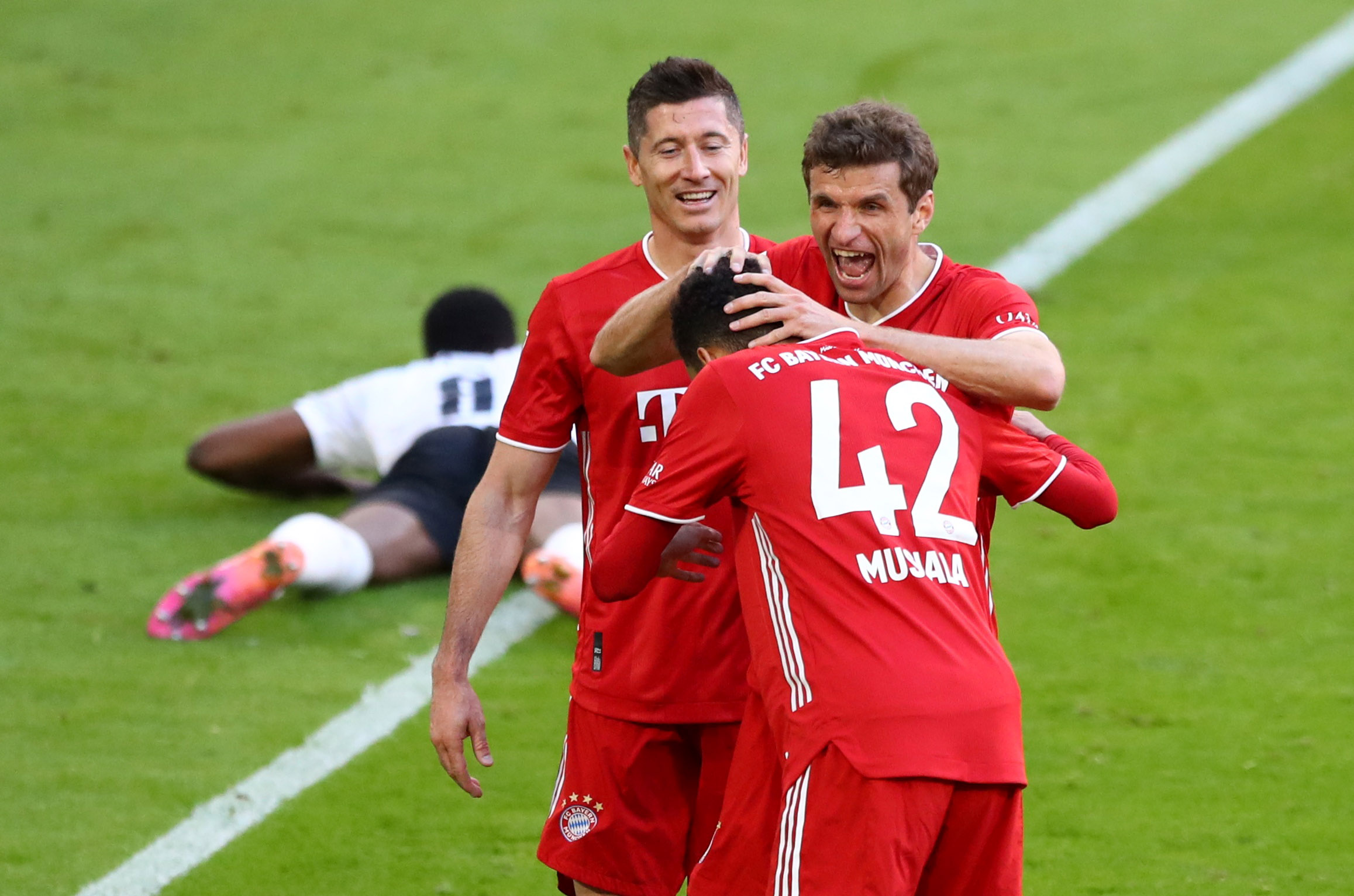 Soccer Football - Bundesliga - Bayern Munich v Borussia Moenchengladbach - Allianz Arena, Munich, Germany - May 8, 2021 Bayern Munich's Thomas Muller celebrates scoring their second goal with Robert Lewandowski and Jamal Musiala Pool via REUTERS