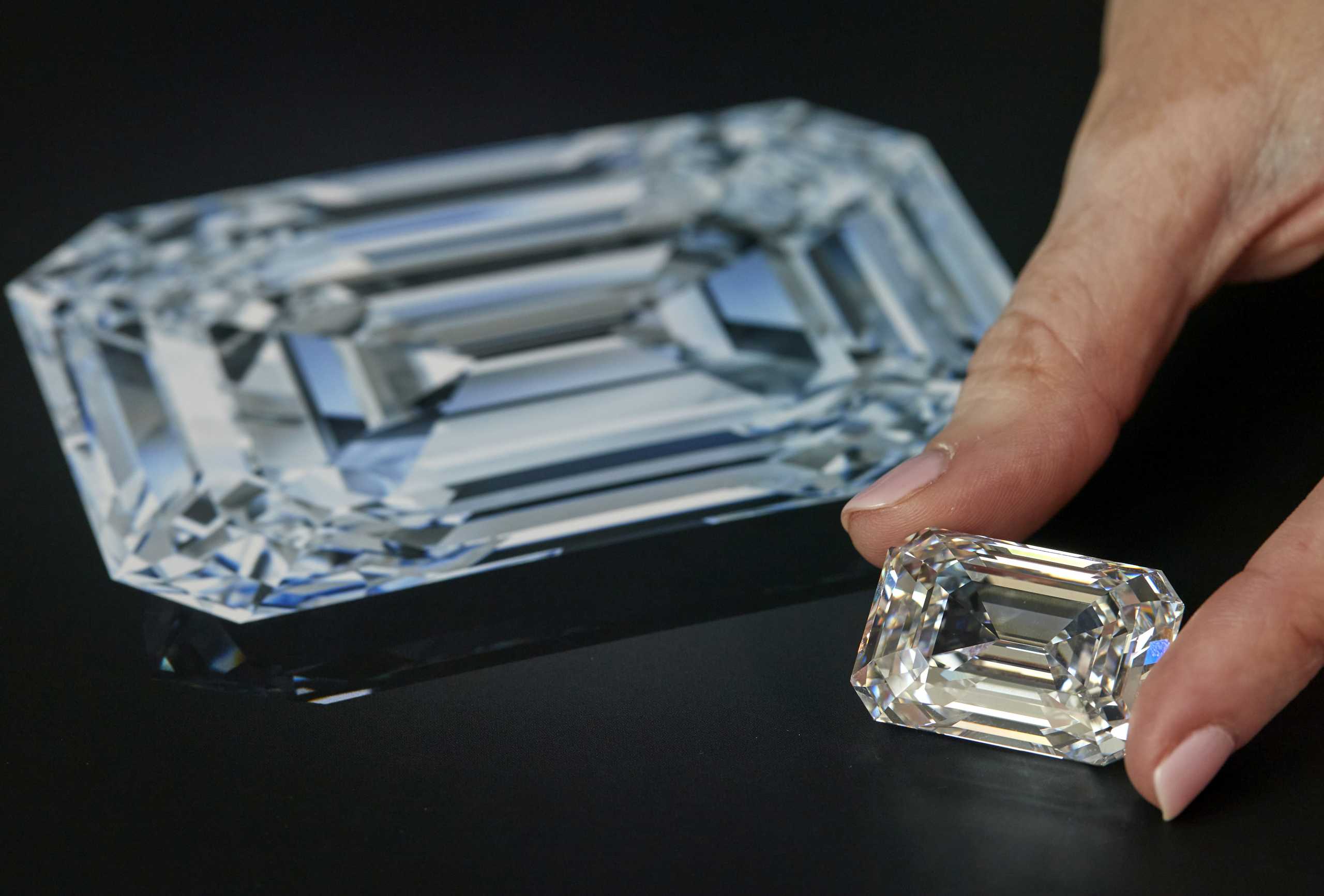 A staff holds a D colour, internally flawless rectangular step-cut diamond of 100.94 carats during a preview at Christie's before its auction sale in Geneva, Switzerland, May 7, 2021.  REUTERS
