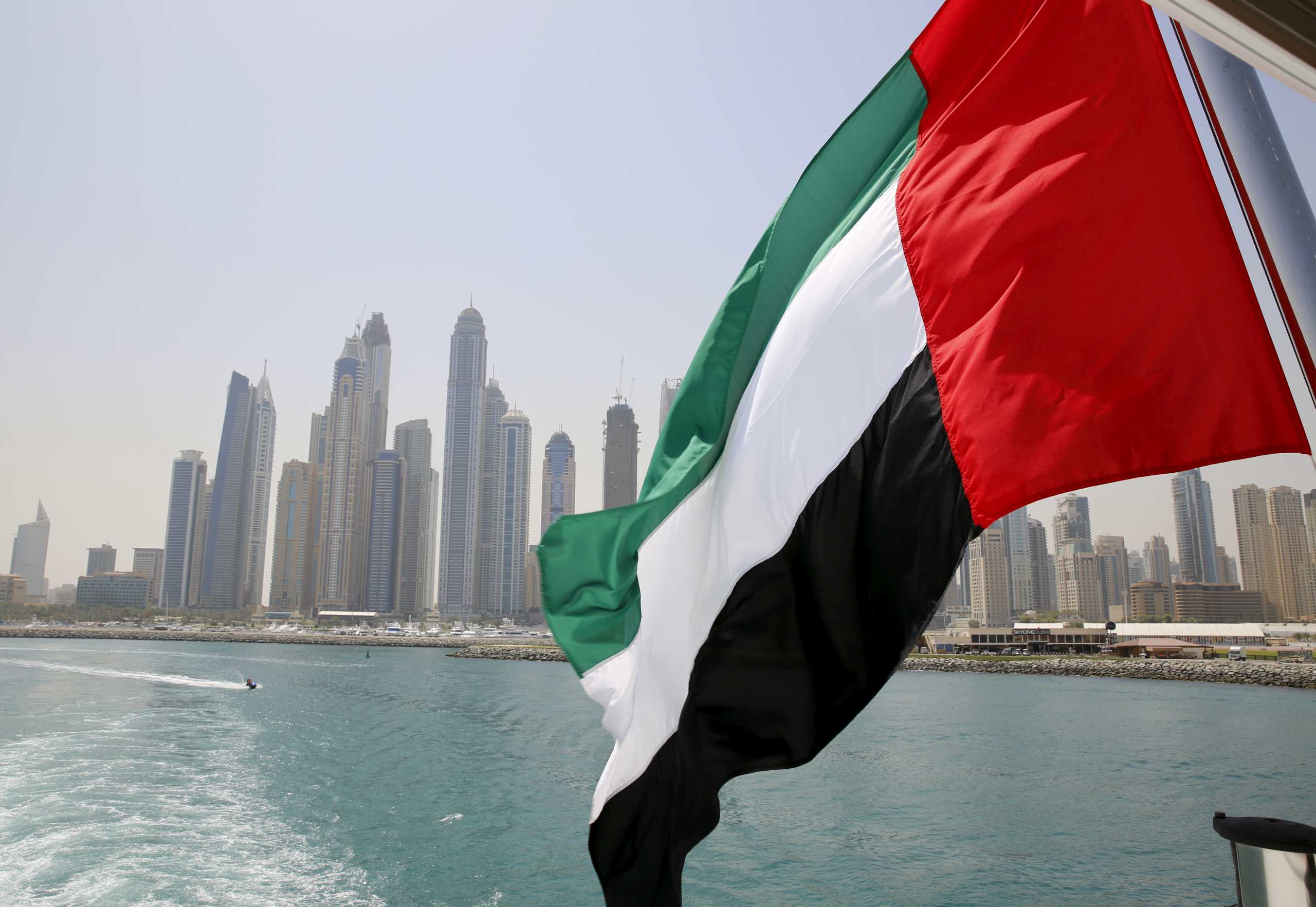 FILE PHOTO: UAE flag flies over a boat at Dubai Marina, Dubai, United Arab Emirates May 22, 2015. REUTERS