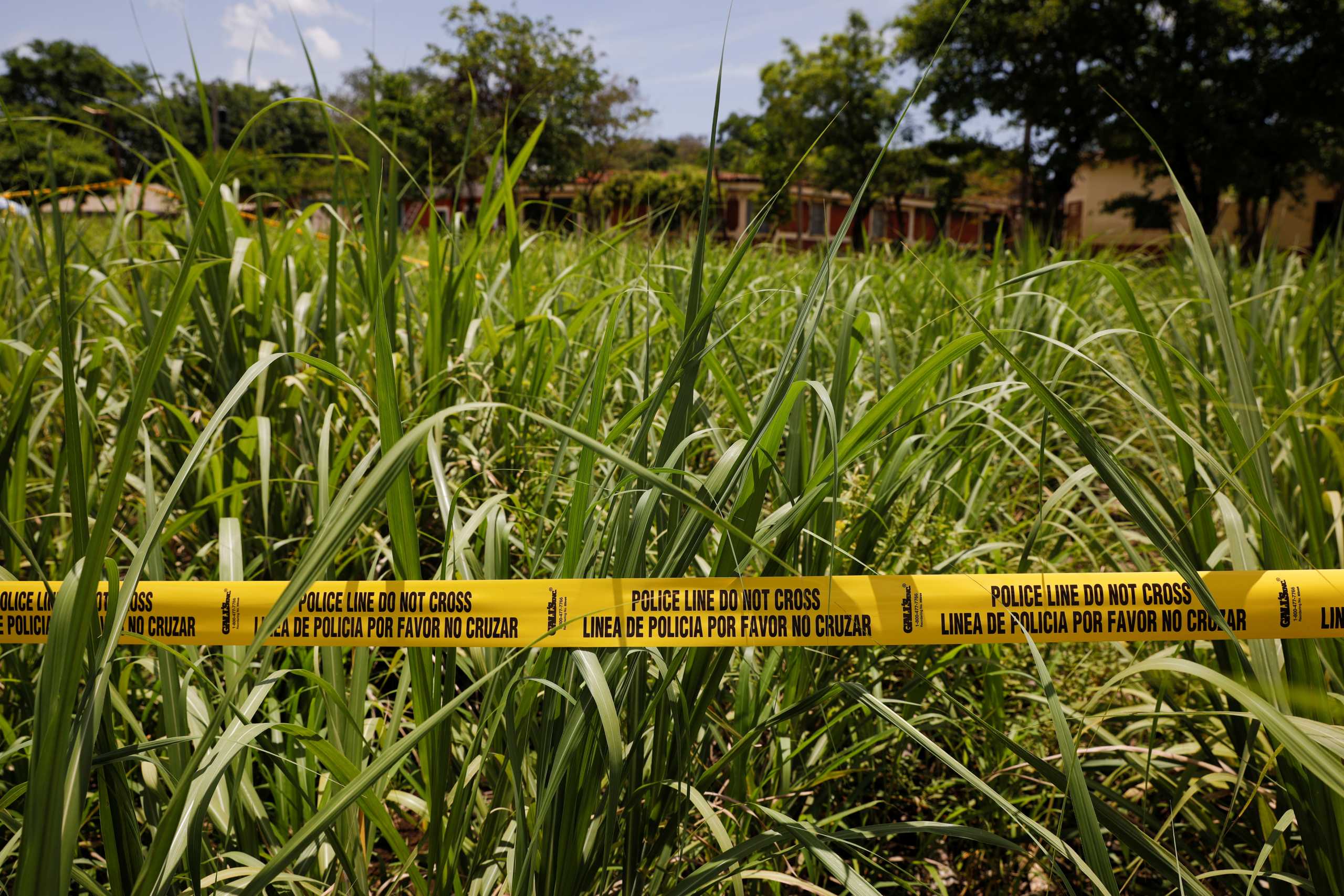 A police line is seen at the place where authorities are excavating a clandestine cemetery discovered at the house of a former police officer and containing many bodies, most of them believed to be women, in Chalchuapa, El Salvador May 27, 2021. REUTERS