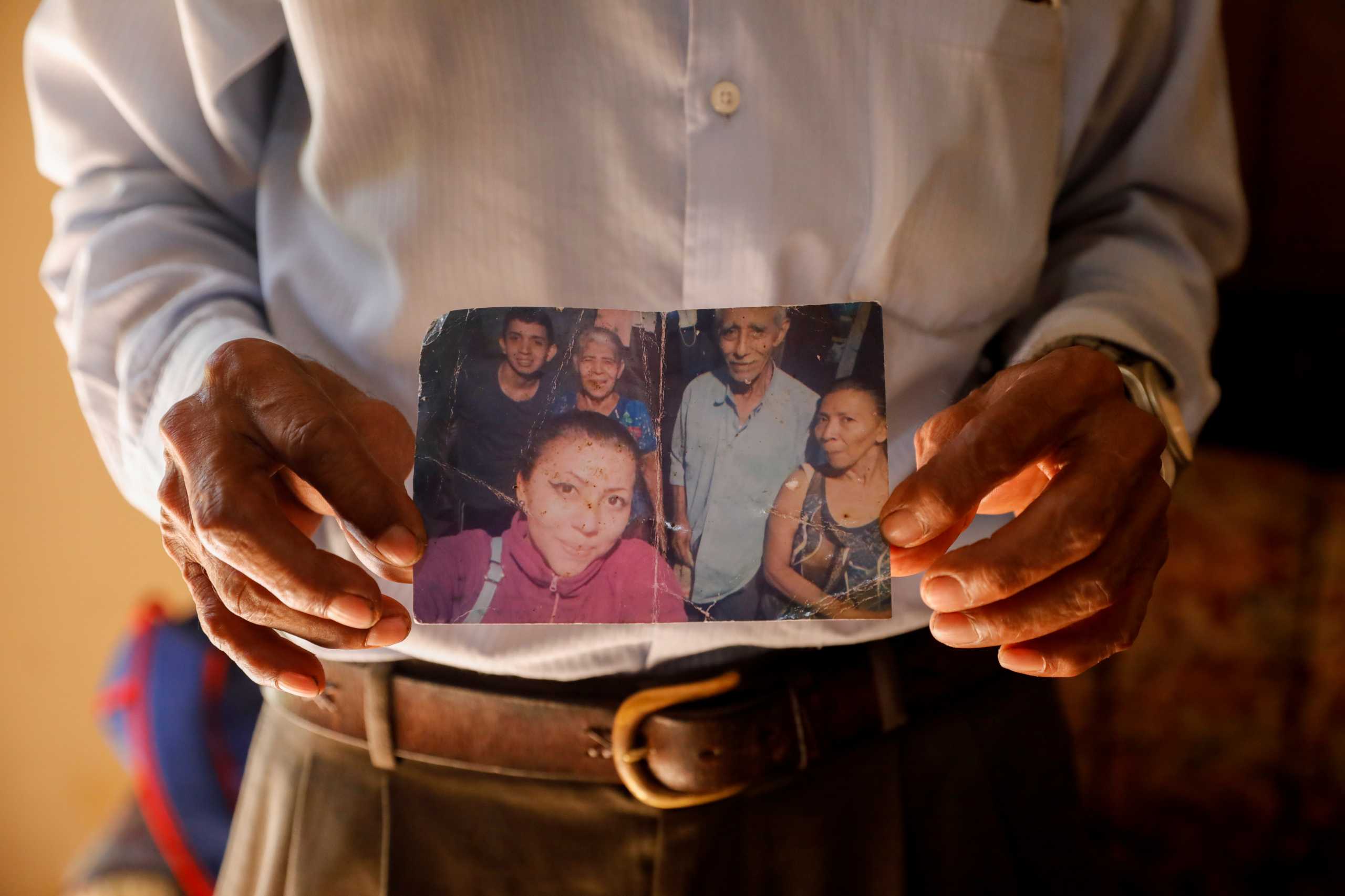 Jose de la Cruz, father of Mirna Cruz Lima and grandfather of Jacquelinne Palomo Lima and Alexis Palomo Lima, who were murdered by former policeman Hugo Ernesto Osorio Chavez in Chalchuapa, shows a picture of his relatives during an interview with Reuters in Santa Ana, El Salvador May 27, 2021. REUTERS