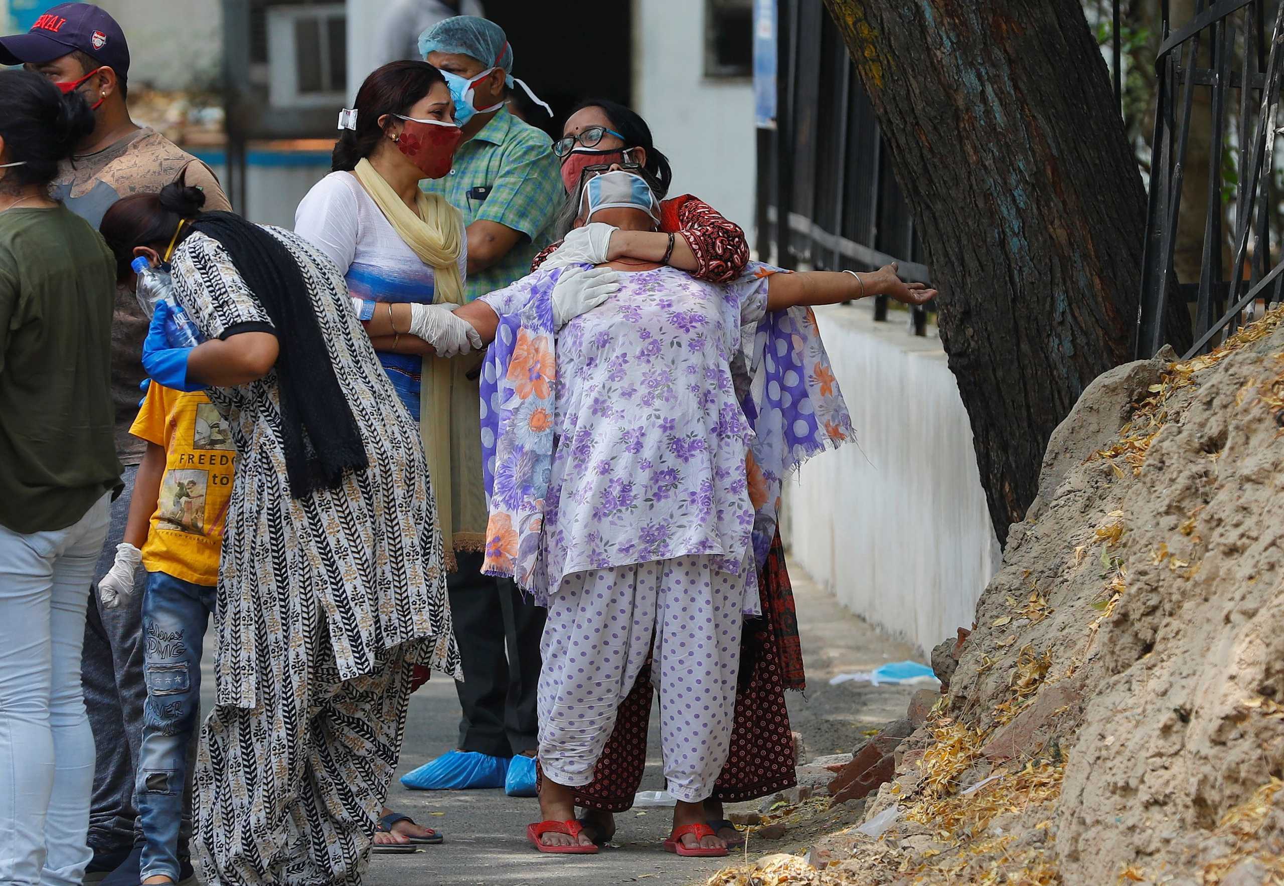 A woman mourns after seeing the body of her son who died due to the coronavirus disease (COVID-19), outside a mortuary of a COVID-19 hospital in New Delhi, India, May 12, 2021. REUTERS