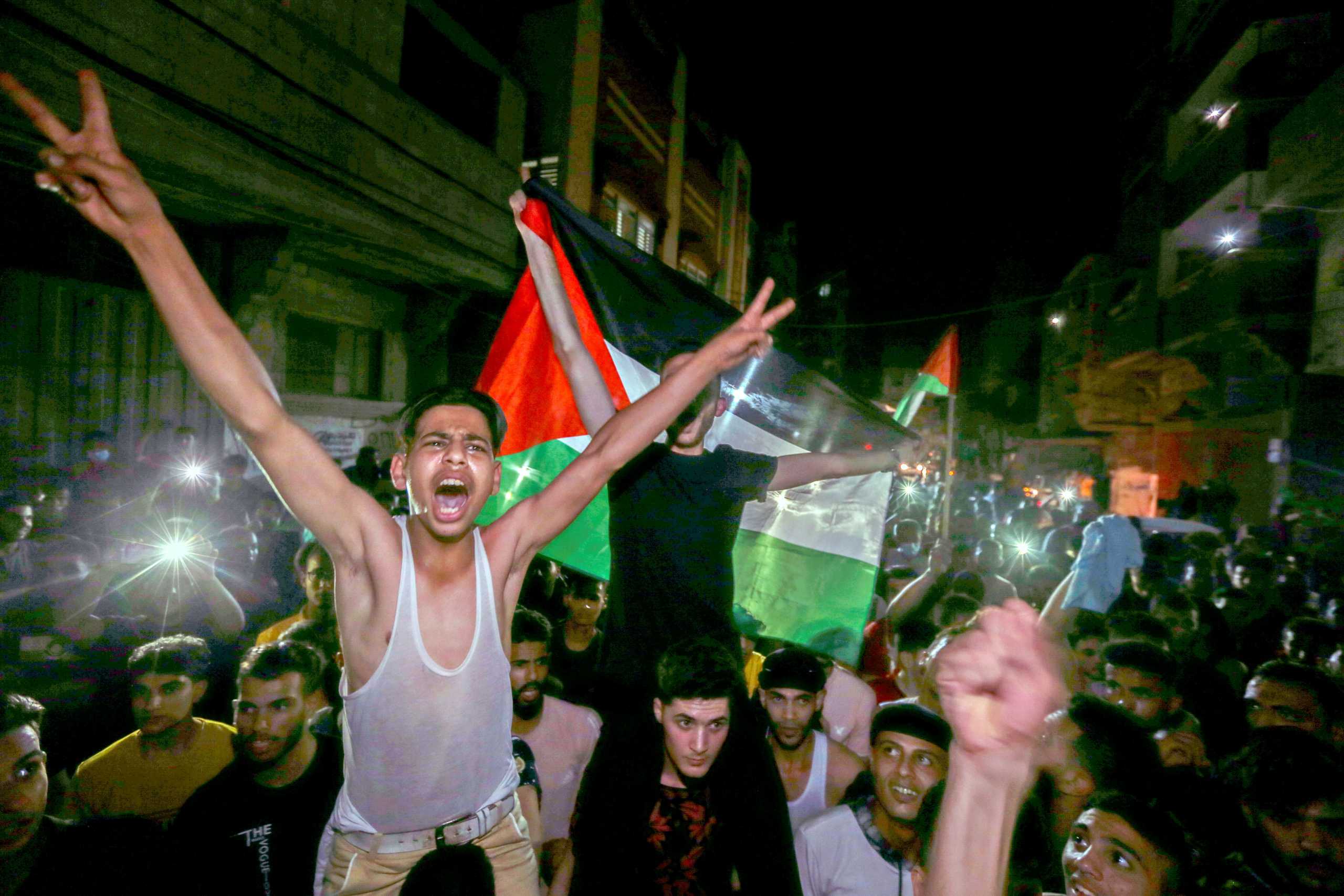 Palestinians celebrate in the streets following a ceasefire, in the southern Gaza Strip May 21, 2021. REUTERS